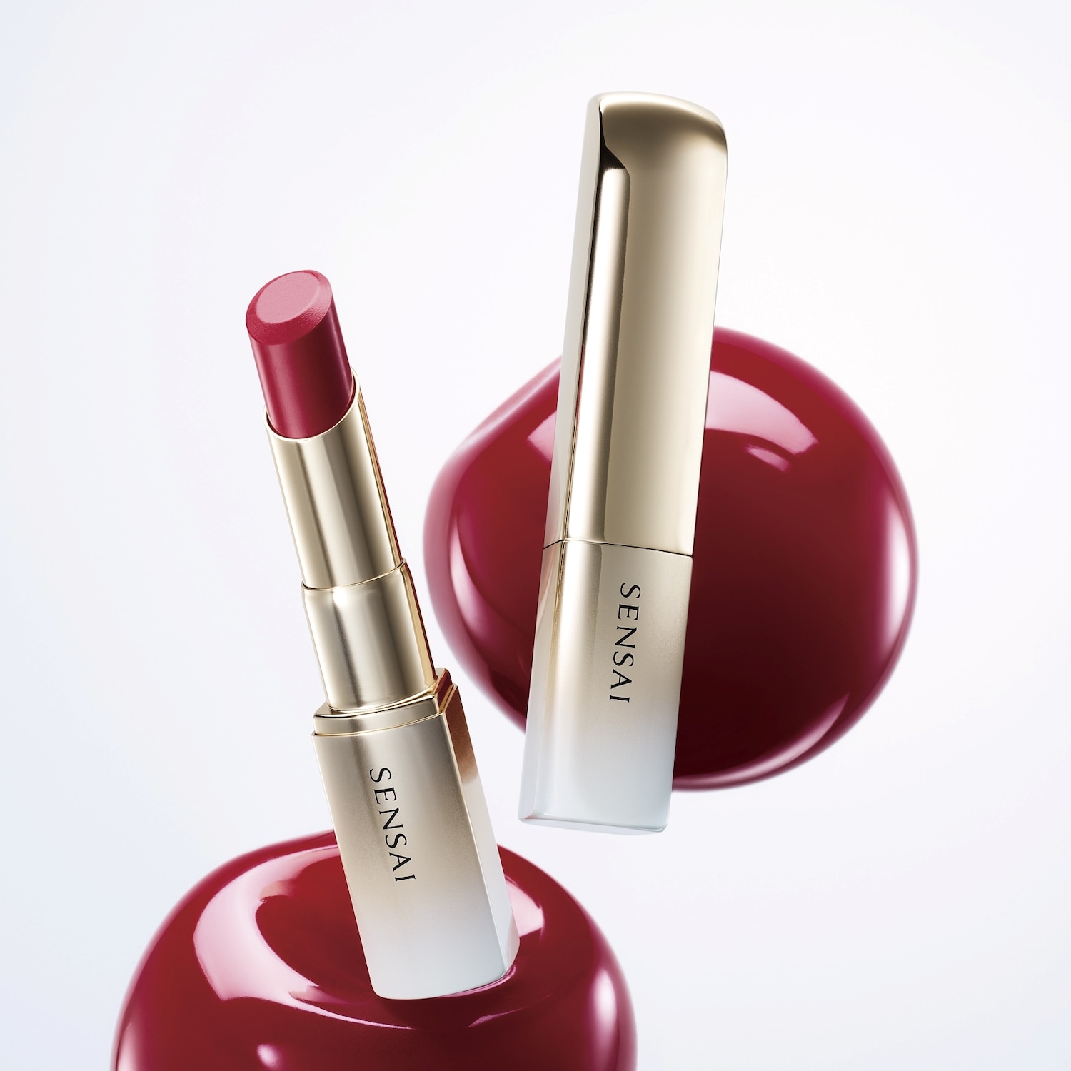 Découvrez le rouge à lèvres Sensai, un écrin doré dévoilant une teinte rouge profonde, sublimée par un fond rouge brillant.