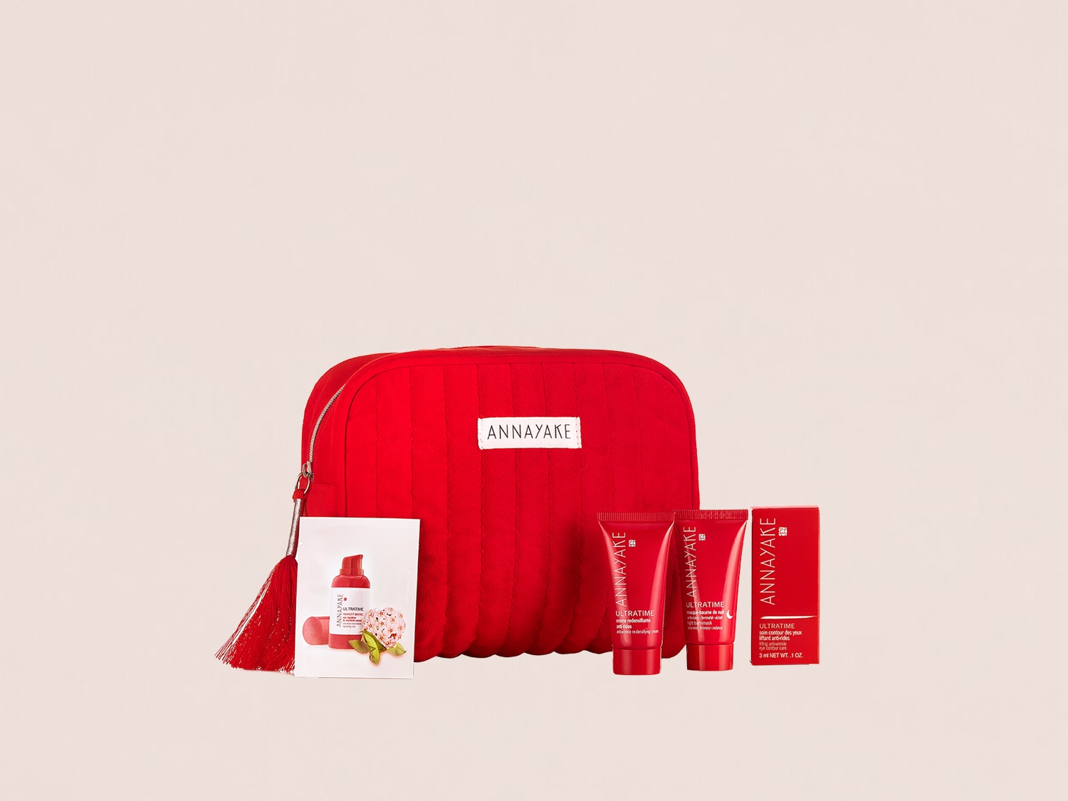Entdecken Sie das ANNAYAKE Ultratime Set, bestehend aus einer roten Kosmetiktasche, Hautpflegeprodukten und einer Tuchmaske für eine umfassende Schönheitsroutine.
