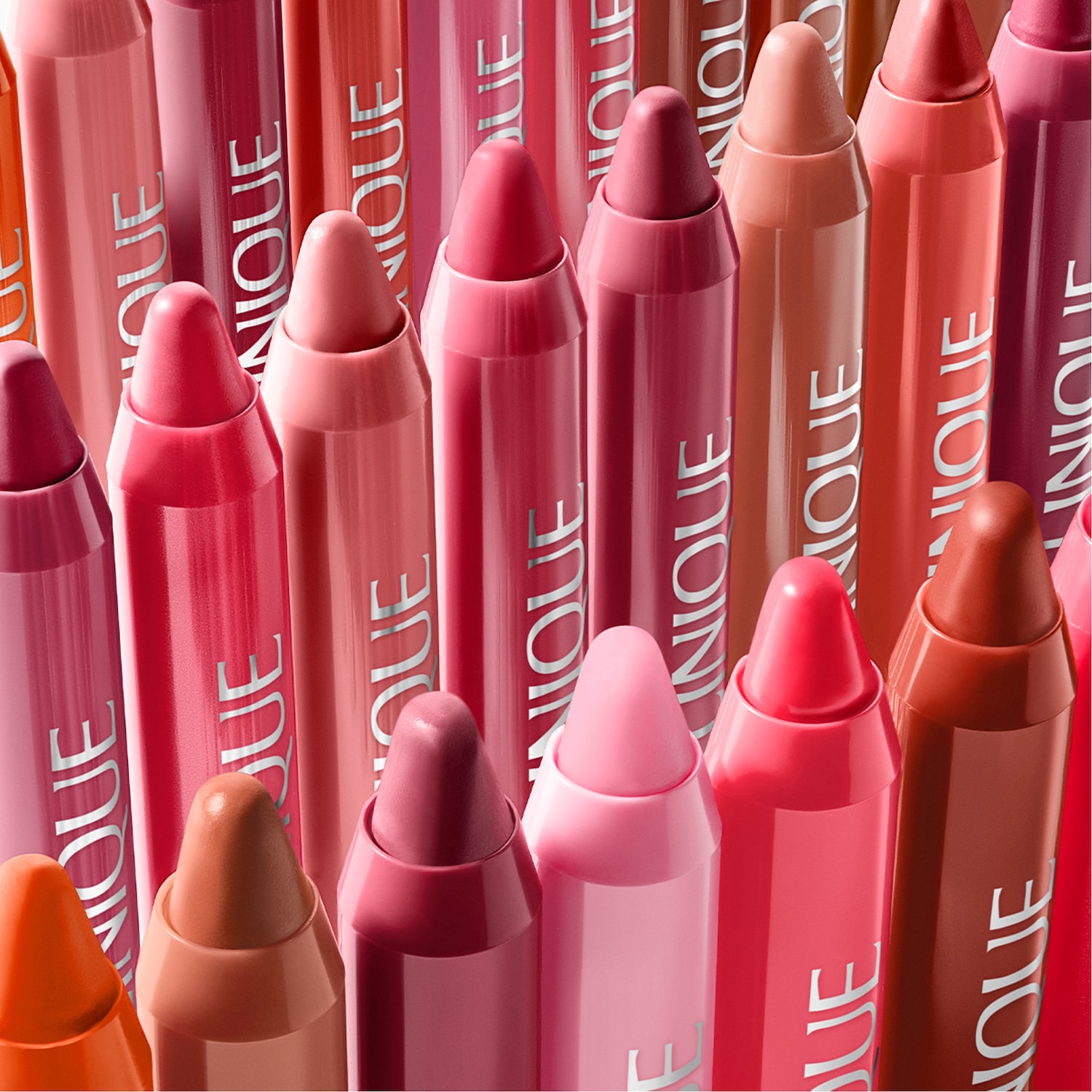 Nahaufnahme von nebeneinander aufgereihten Cliniques Chubby Stick Moisturizing Lip Color Balms in verschiedenen Rosa- und Rottönen.