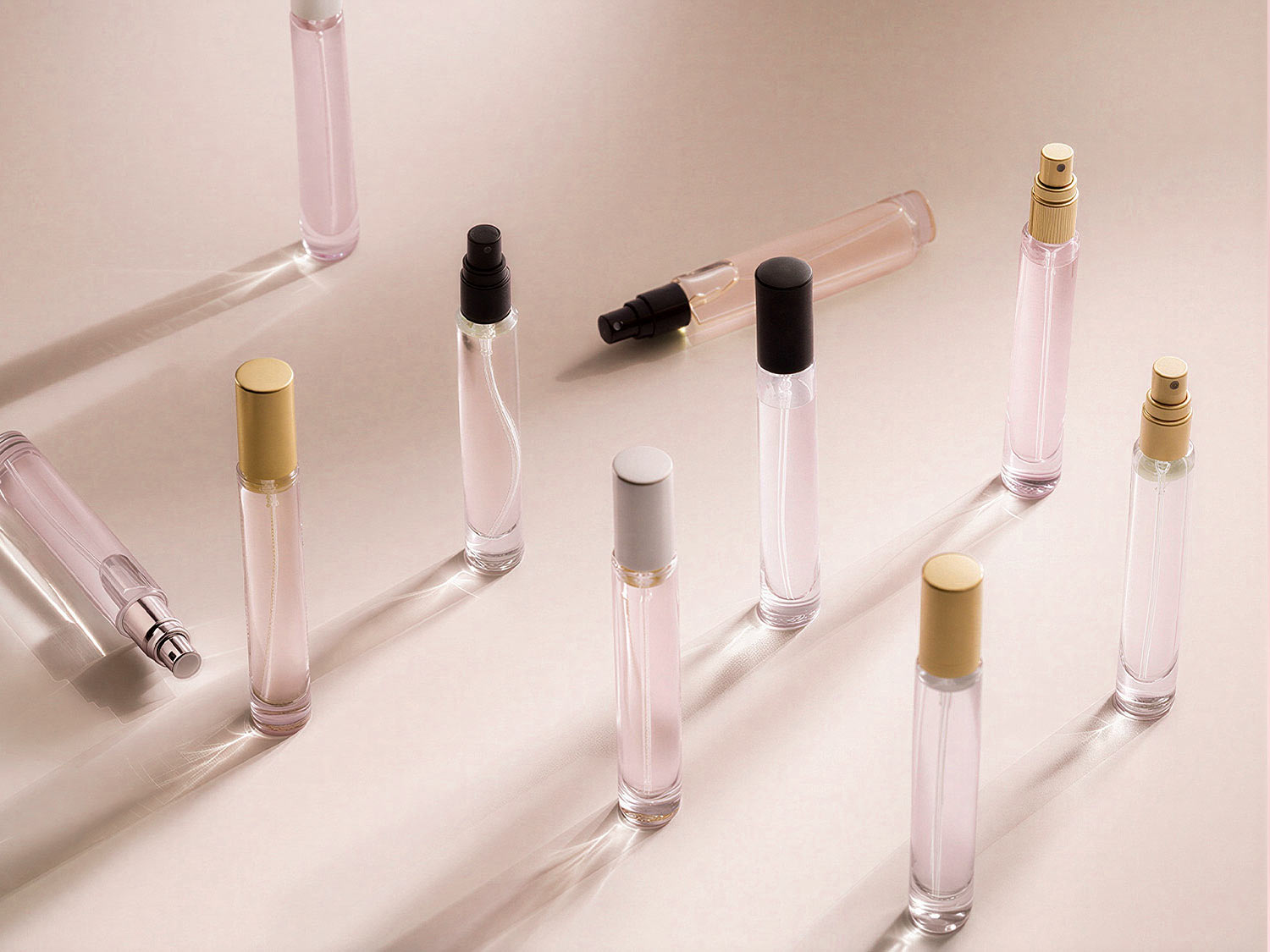 Eine Anordnung von durchsichtigen Parfümflaschen mit verschiedenen farbigen Kappen, die ein elegantes und minimalistisches Erscheinungsbild bieten.