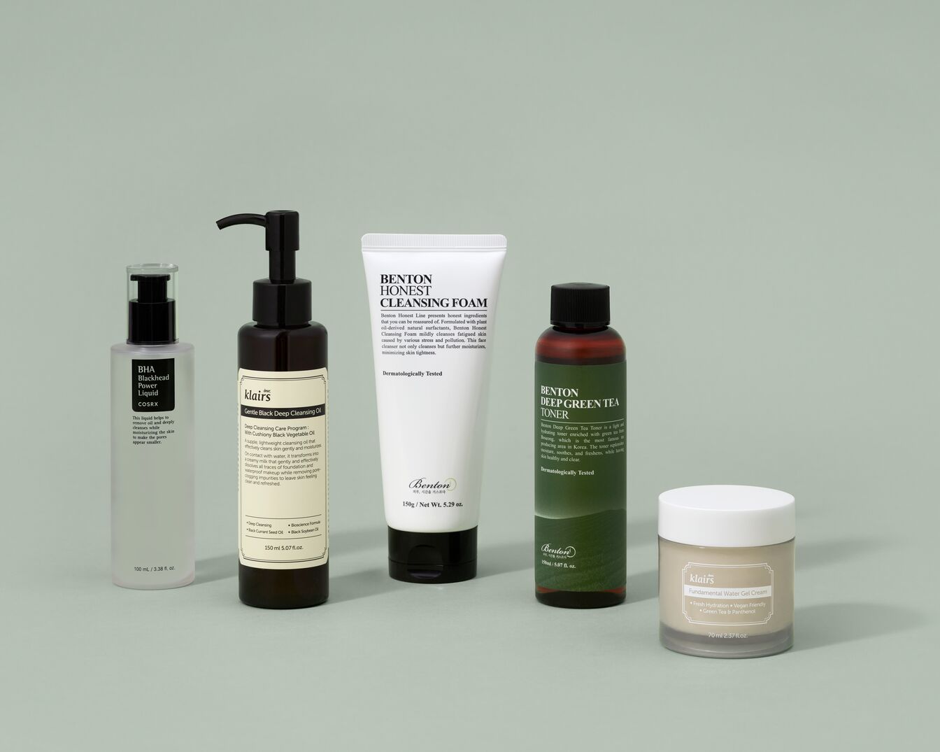 Une gamme de produits de soins de la peau comprenant des nettoyants, des toniques et des crèmes hydratantes, présentés dans des emballages minimalistes sur un fond vert uni.
