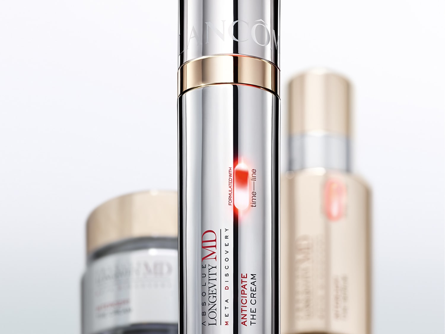 Primo piano di una confezione color argento di Lancôme Absolue Longevity MD Meta Discovery, con scritte rosse e dorate, che promette di anticipare la crema per una linea temporale.