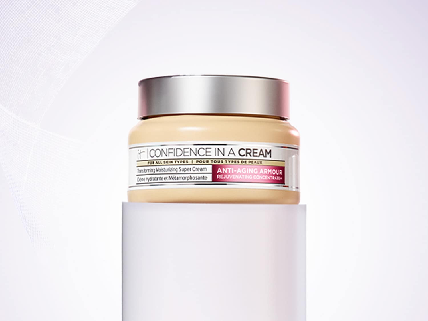 Krem IT Cosmetics Confidence in a Cream w beżowym słoiczku ze srebrnym wieczkiem, obiecujący nawilżenie i działanie przeciwstarzeniowe dla każdego typu skóry.