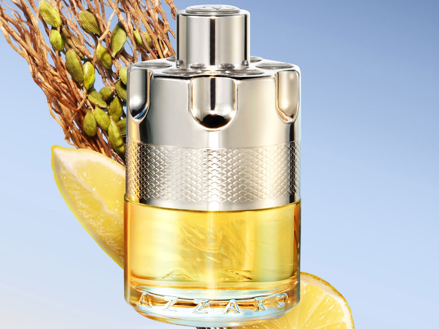 Butelka Azzaro w srebrnym opakowaniu z żółtą cieczą w środku, obok której leżą plasterki cytryny i gałązka z zielonymi pąkami na tle błękitnego nieba.