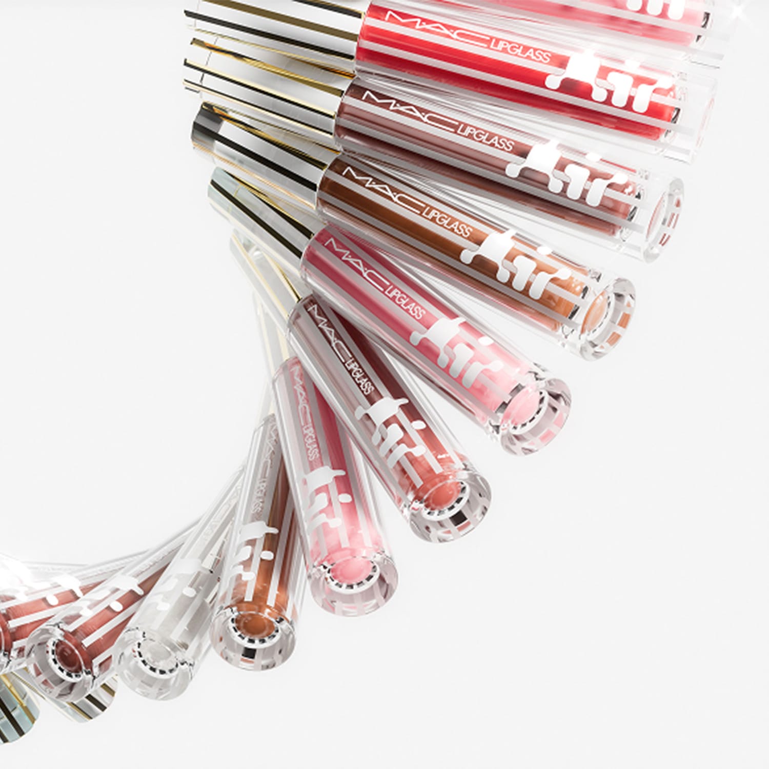 Een reeks MAC Lipglass-tubes in verschillende tinten, van rood tot bruin, met een heldere verpakking en een zilveren dop met strepen.