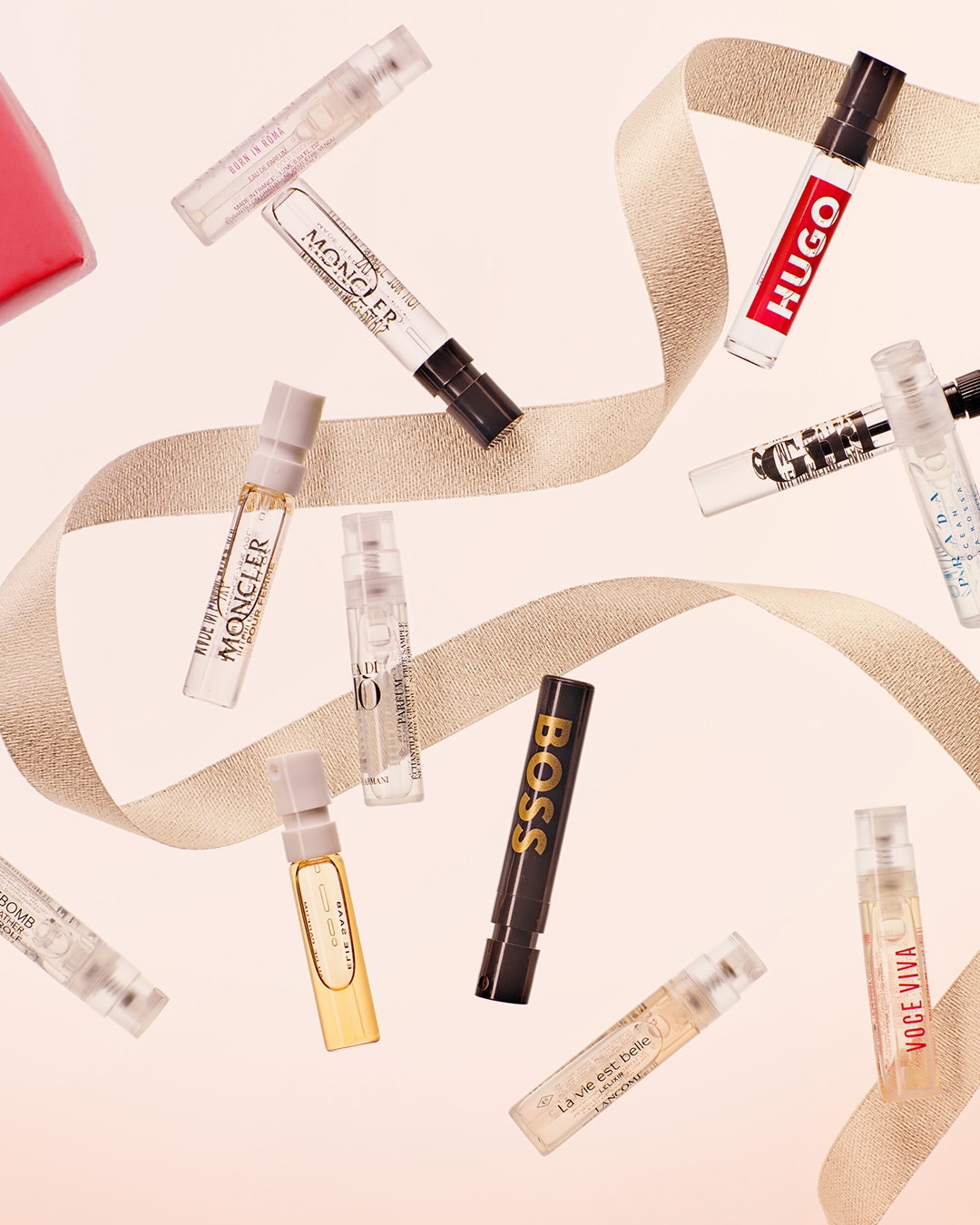 Découvrez un assortiment d'échantillons de parfums de marques renommées telles que Hugo, Boss, Prada, Lancôme et Moncler, présentés sur un ruban doré.