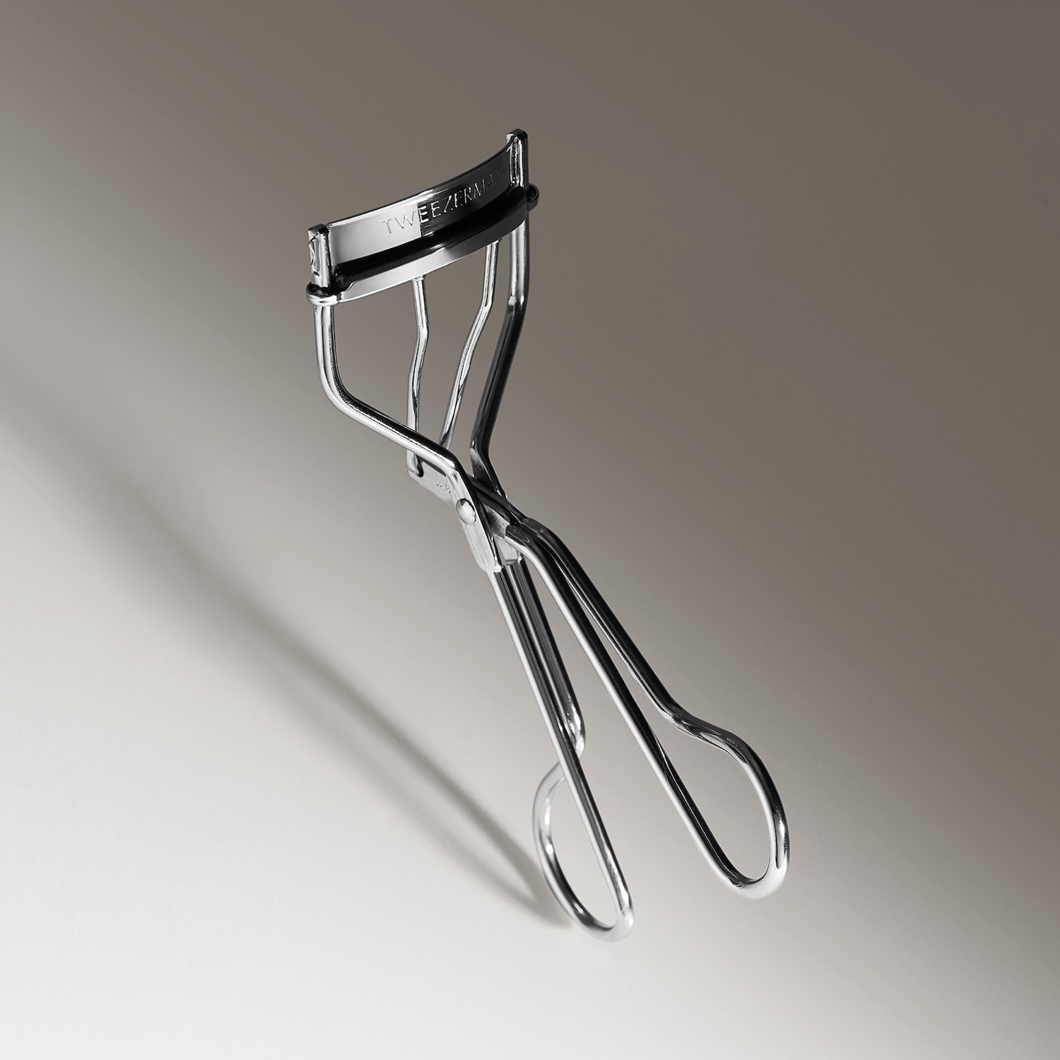 Die silberne Wimpernzange von Tweezer Man mit schwarzem Silikonpolster sorgt für einen perfekten Schwung.