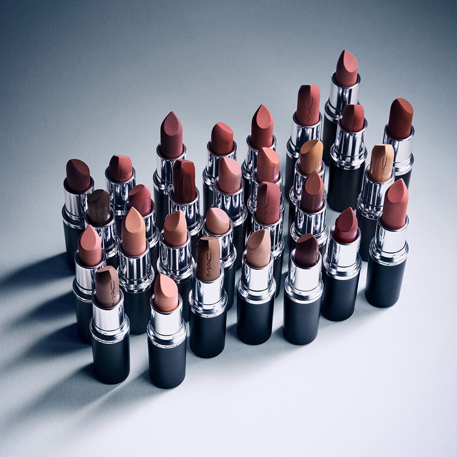 Découvrez une gamme de rouges à lèvres MAC aux teintes nude et naturelles, présentés dans des tubes noirs élégants avec des accents argentés.