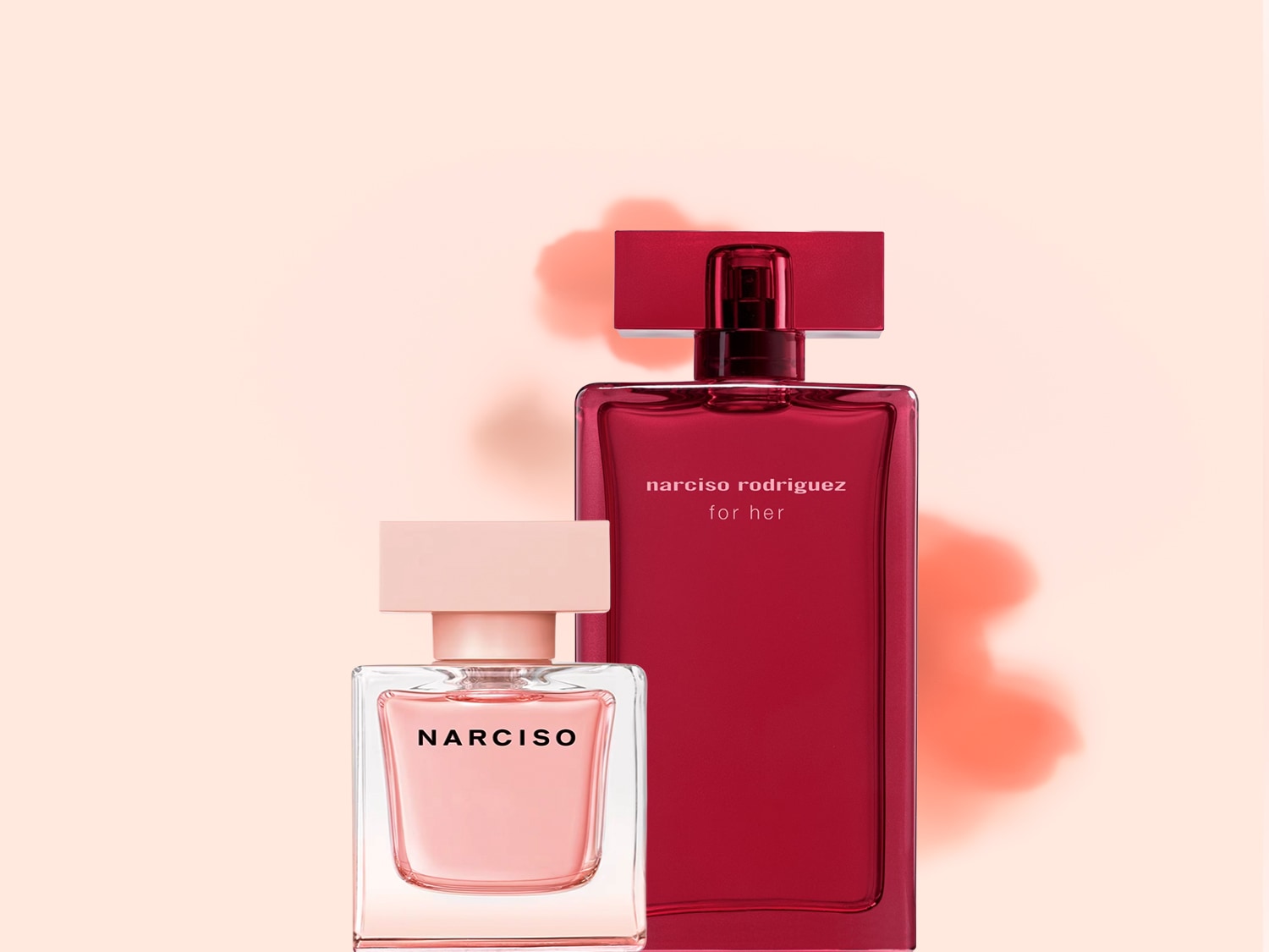 Due flaconi di profumo Narciso Rodriguez, uno rosso scuro e uno rosa chiaro, si ergono eleganti su uno sfondo pesca tenue.