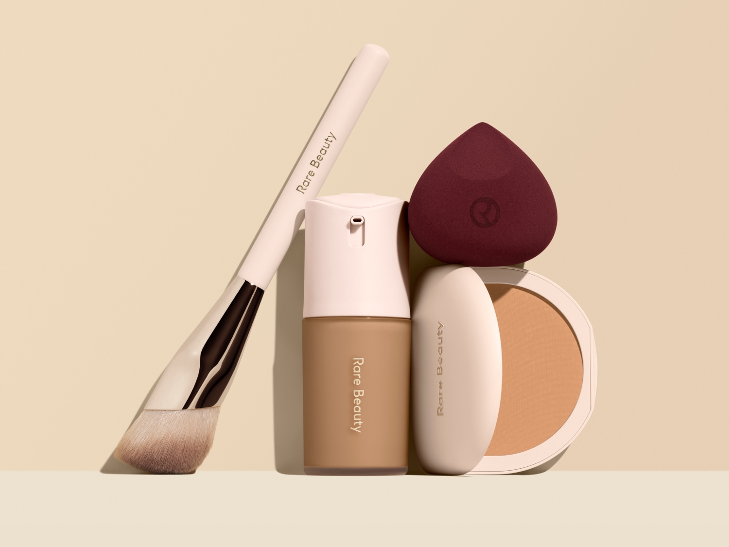 Rare Beauty Make-up-Set mit Pinsel, Foundation, Schwamm und Puder für einen ebenmäßigen Teint.