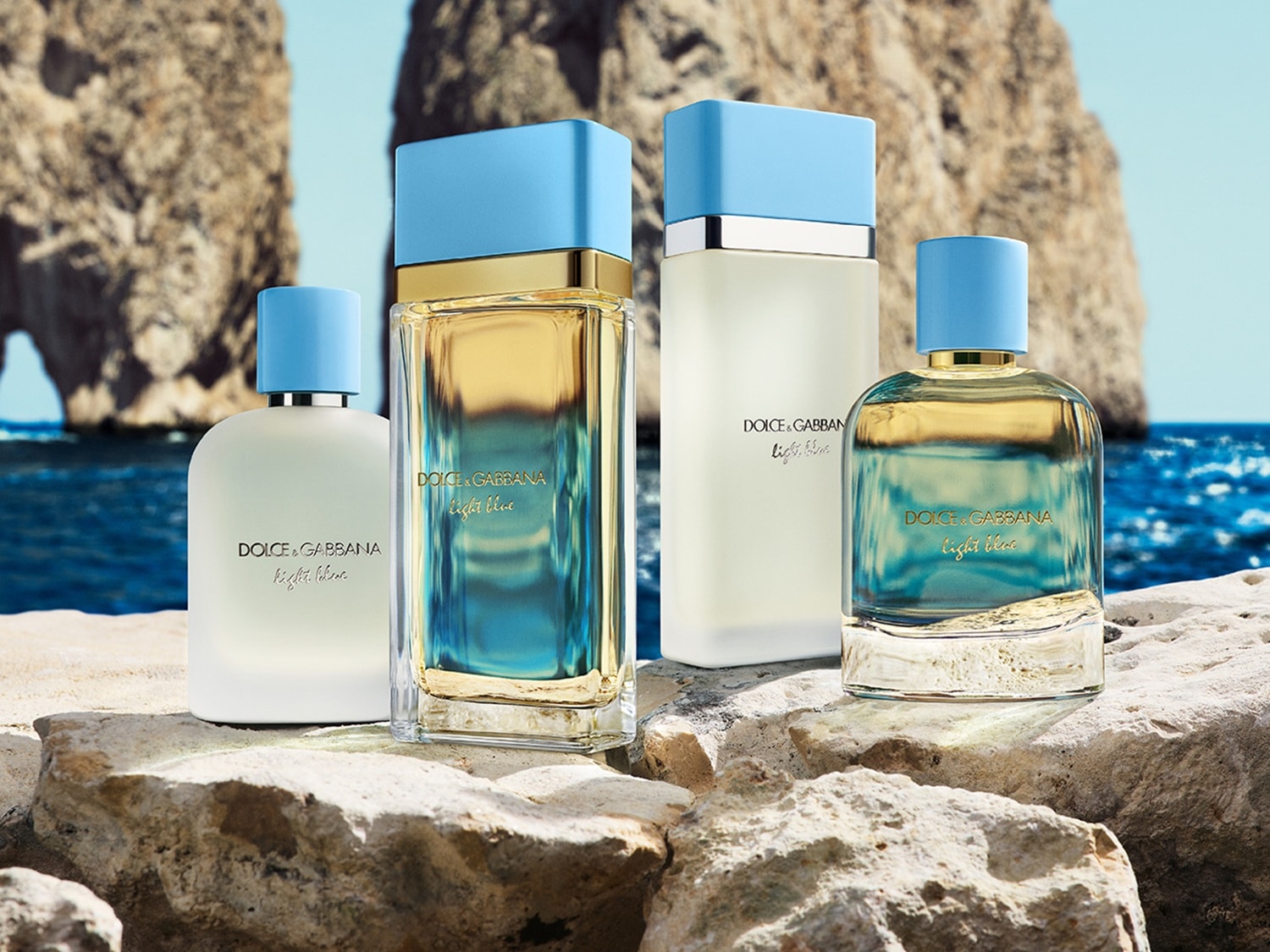 Eine Kollektion von Dolce&Gabbana Light Blue Parfums steht auf einem Felsen mit dem Meer und Felsen im Hintergrund.