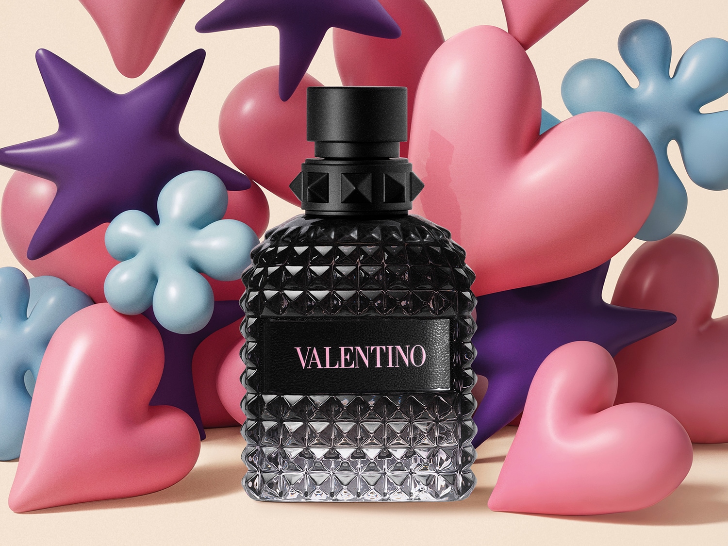 Il flacone di profumo Valentino nero sfaccettato si erge tra cuori rosa, stelle viola e fiori azzurri, creando un'atmosfera giocosa e romantica.