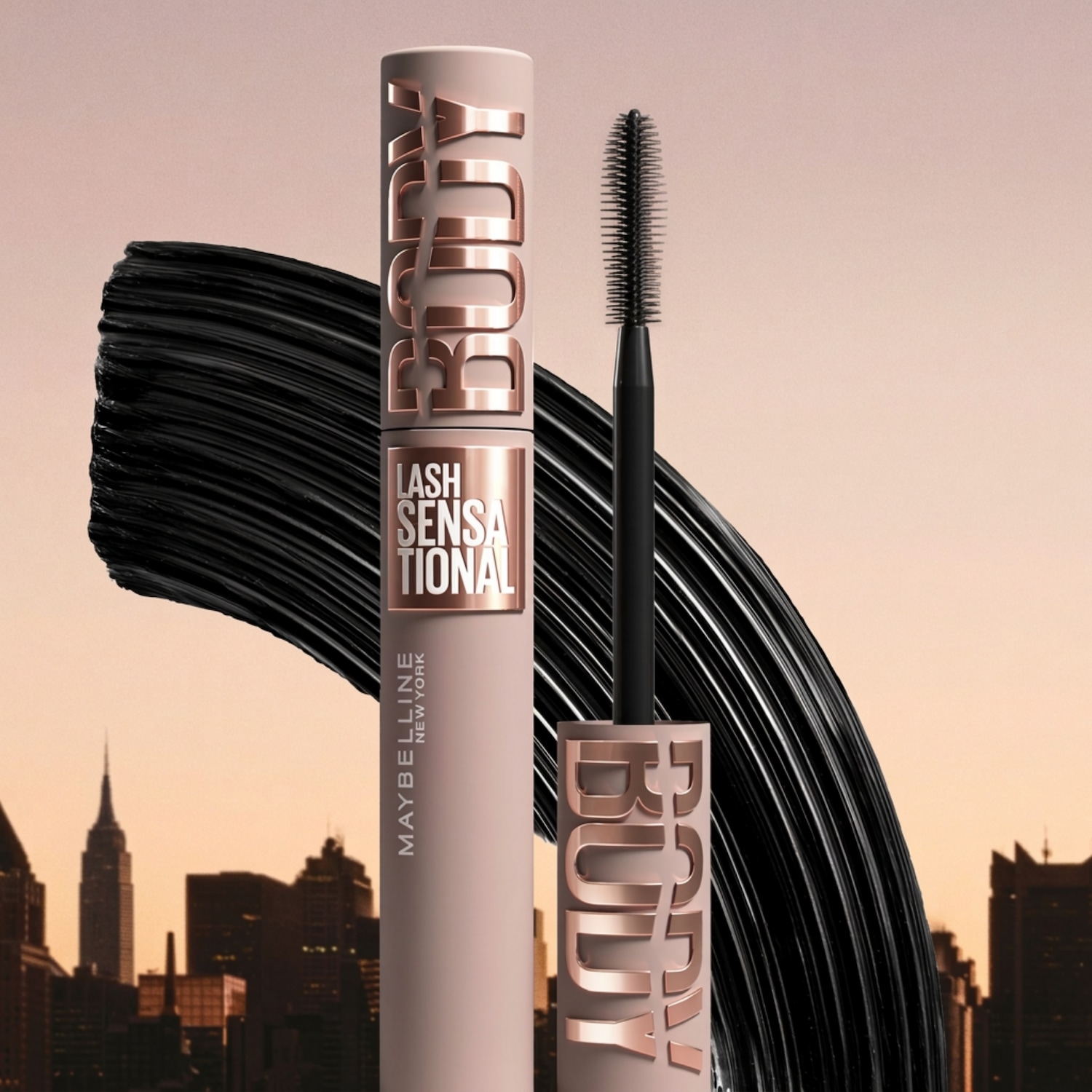 Voici le mascara Lash Sensational de Maybelline New York, dans un tube beige rosé avec des lettres dorées, accompagné d'une brosse et d'une texture noire crémeuse.