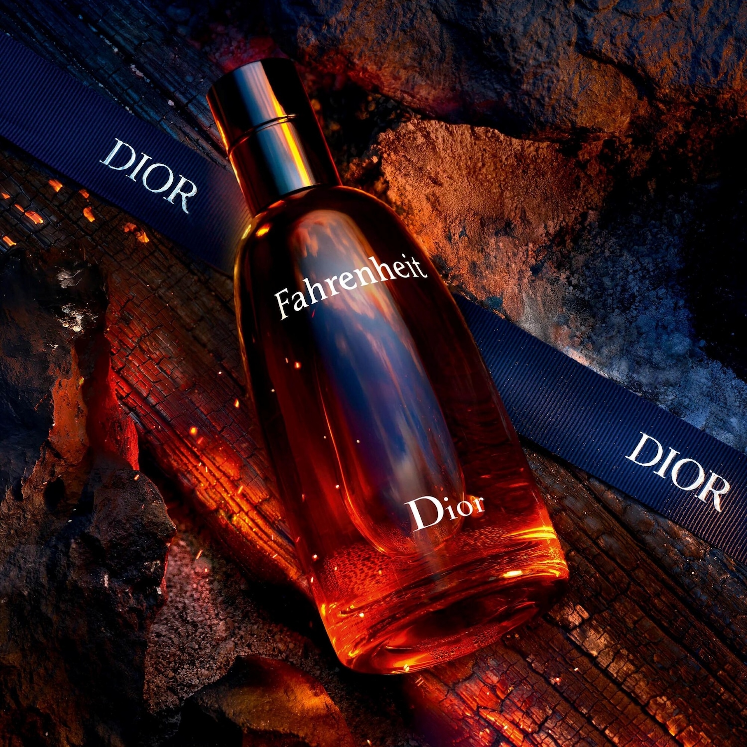 Découvrez Fahrenheit de Dior, un parfum ambré et sophistiqué présenté dans un flacon rouge-orangé élégant, sublimé par un ruban bleu marine portant la signature Dior.