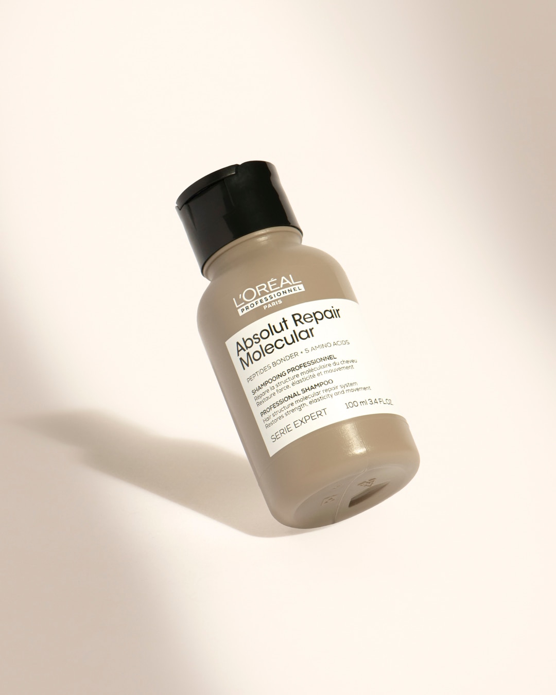 Le shampooing professionnel L'Oréal Professionnel Paris Absolut Repair Molecular, présenté dans une bouteille gris clair de 100 ml avec un bouchon noir, répare la structure moléculaire des cheveux et restaure leur force, élasticité et mouvement.