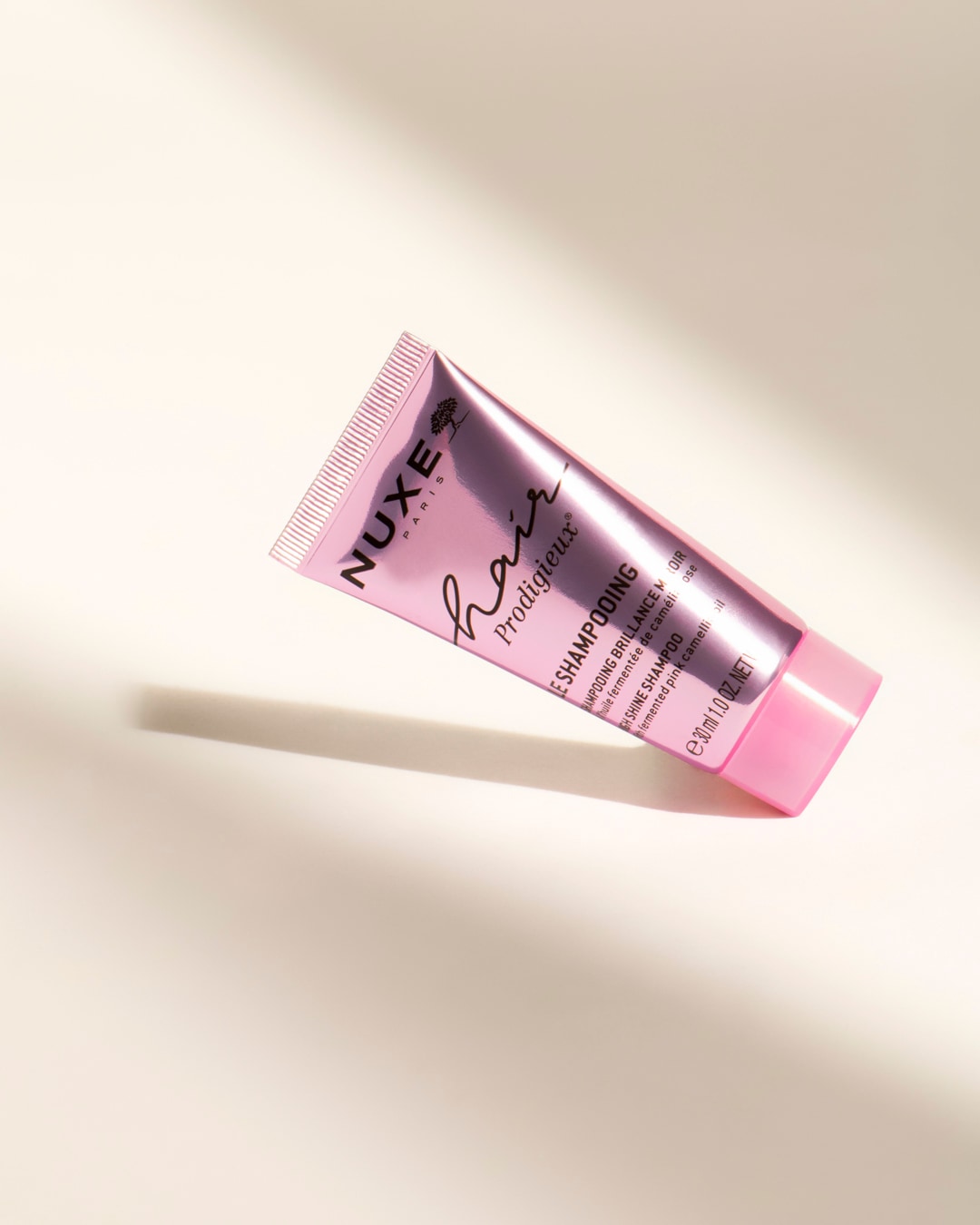 Le shampooing NUXE Hair Prodigieux, présenté dans un tube rose de 30 ml, est formulé avec de l'huile de camélia rose fermentée pour une brillance miroir.