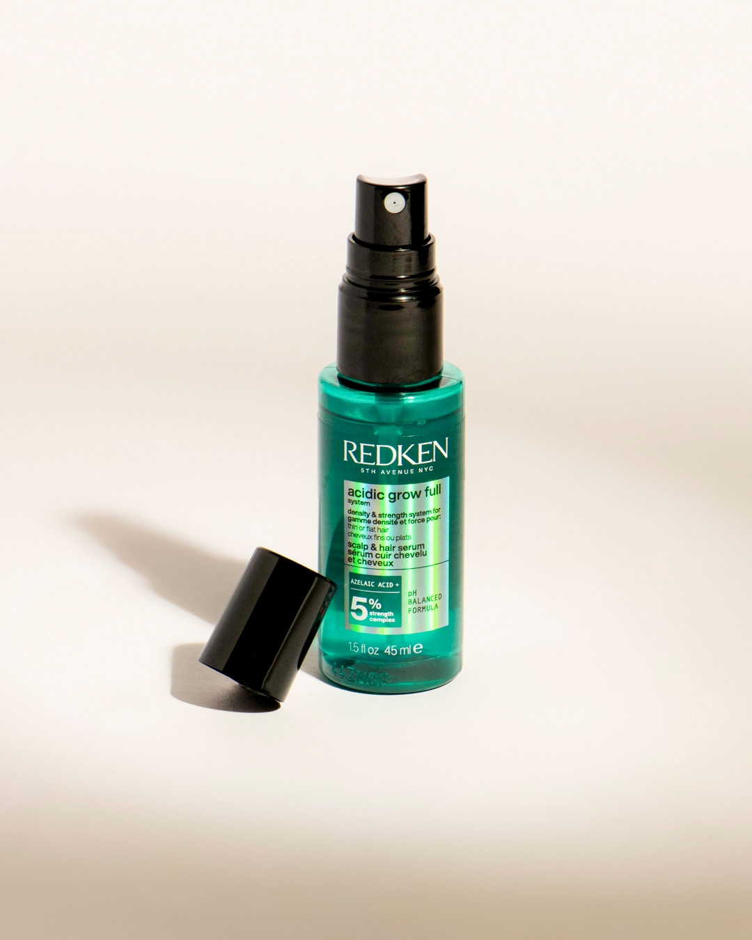 Le sérum capillaire Redken Acidic Grow Full, présenté dans un flacon pulvérisateur vert sarcelle de 45 ml avec un bouchon noir, est formulé avec 5 % d'acide azélaïque pour la densité et la force des cheveux fins ou plats.