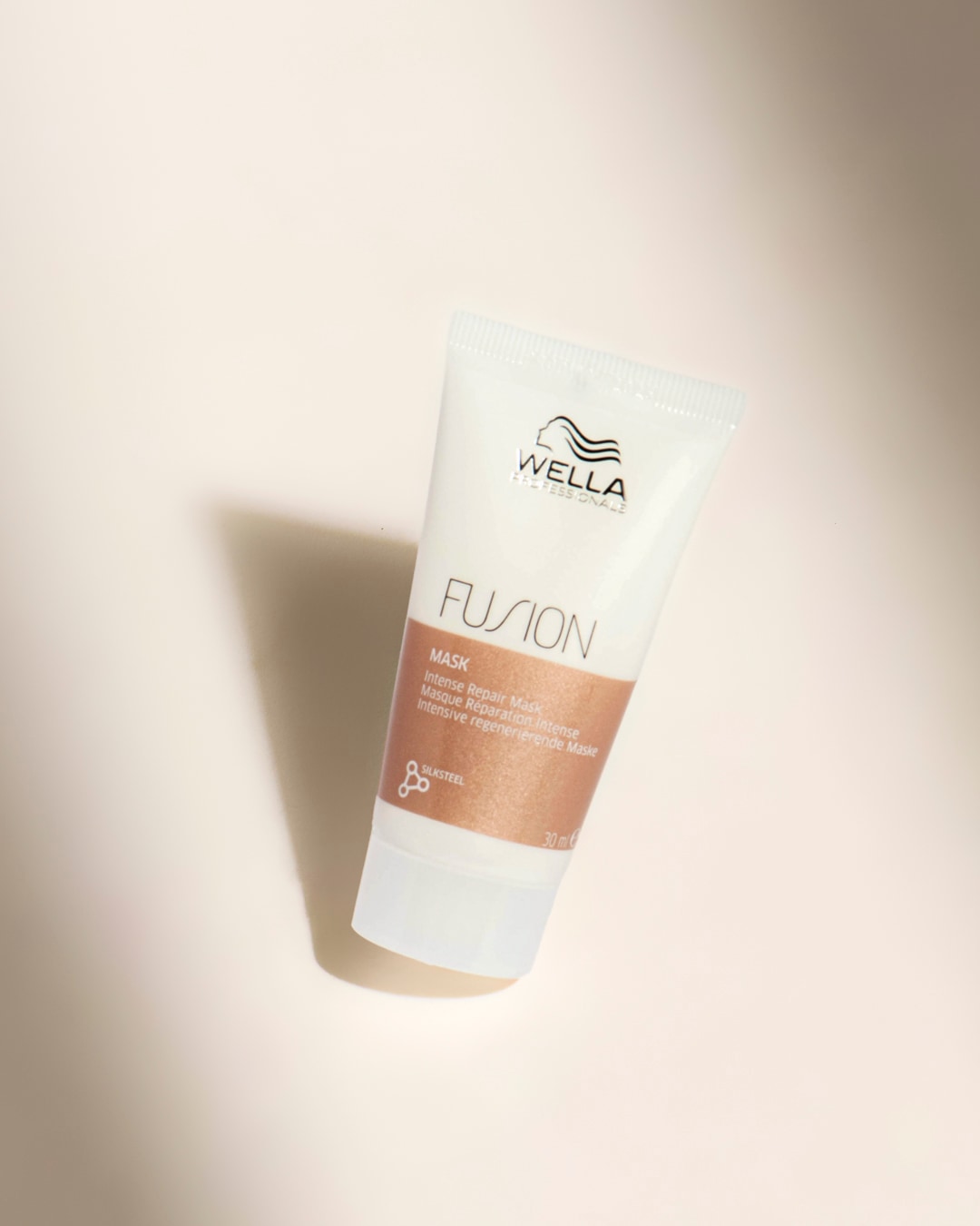 Le masque réparateur intense Wella Professionals Fusion, présenté dans un tube blanc de 30 ml avec des accents cuivrés, est conçu pour réparer et régénérer les cheveux abîmés.