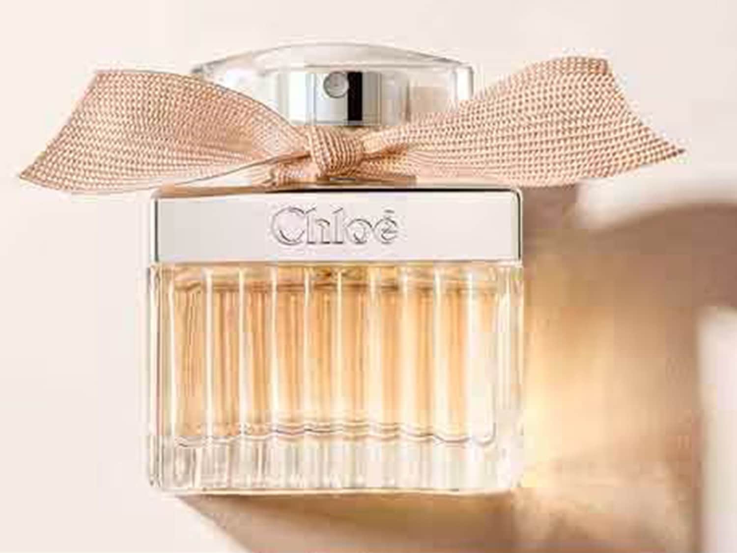 Sticlă de parfum Chloé, cu o fundă bej delicată, adaugă o notă sofisticată oricărei colecții.