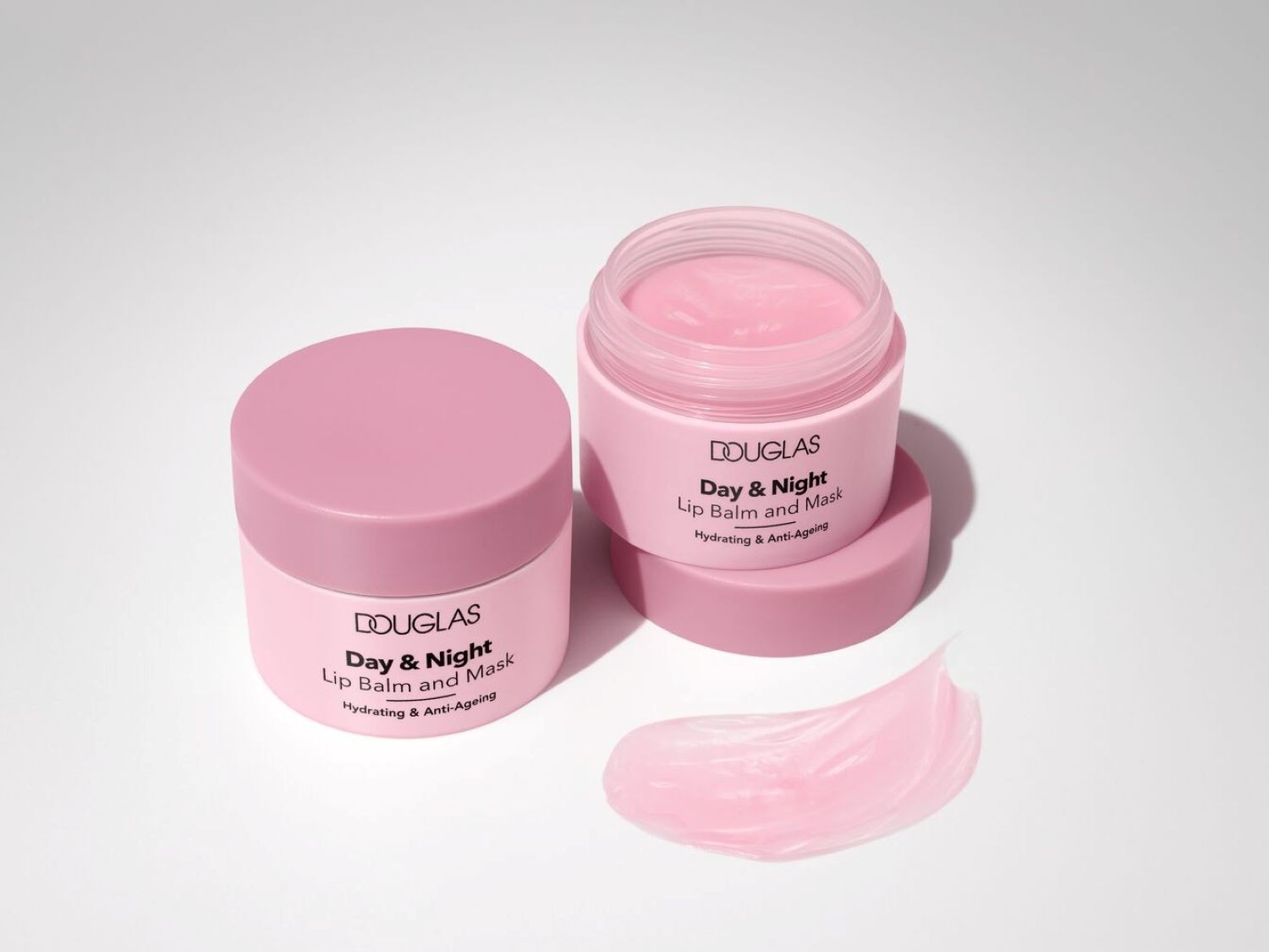 Ecco il balsamo labbra e maschera Douglas Day & Night in un vasetto rosa chiaro, progettato per idratare e combattere i segni dell'età, con una texture liscia e invitante.