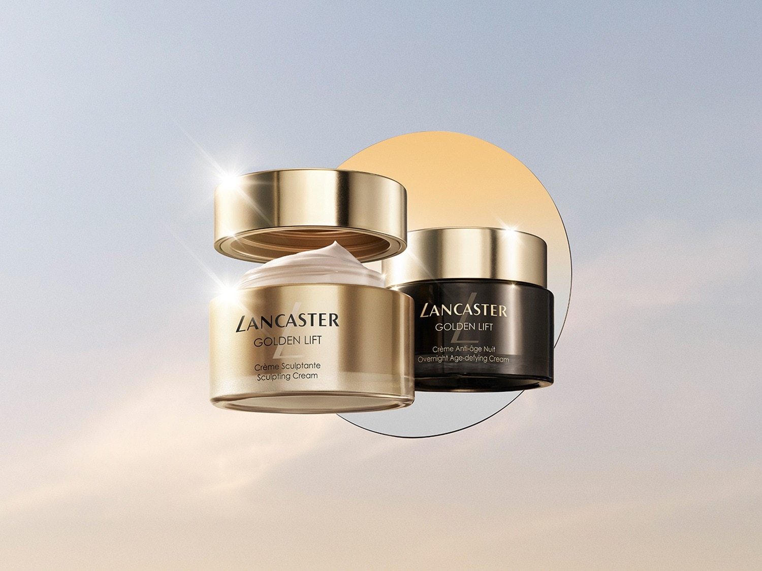 Twee potten Lancaster Golden Lift crème, één gouden pot met open deksel en witte crème, en één zwarte pot, beide voor een sculpting en anti-aging effect.