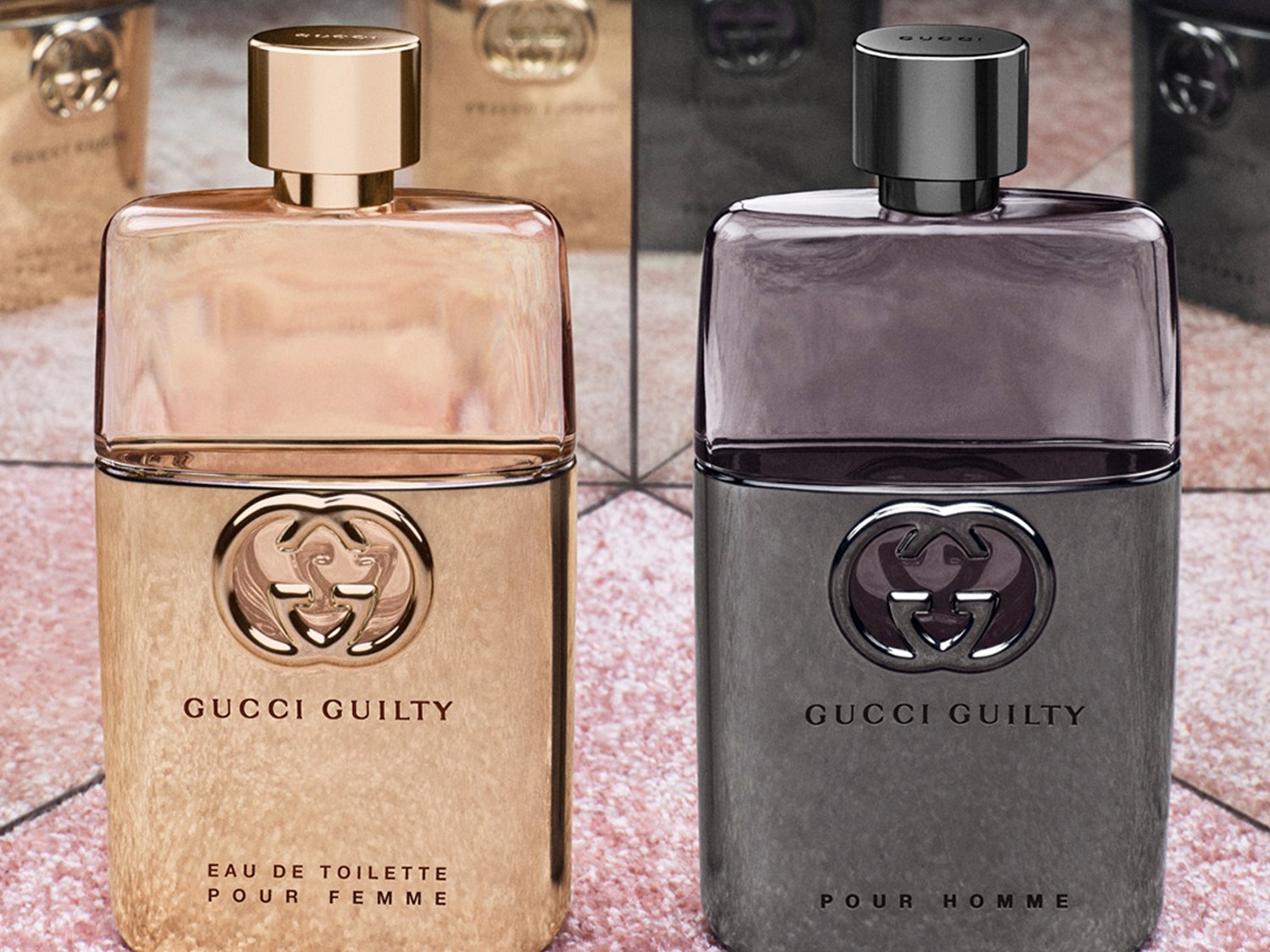 Două sticle de parfum Gucci Guilty, una aurie pentru femei și una gri pentru bărbați, ambele prezentând logo-ul distinctiv Gucci.