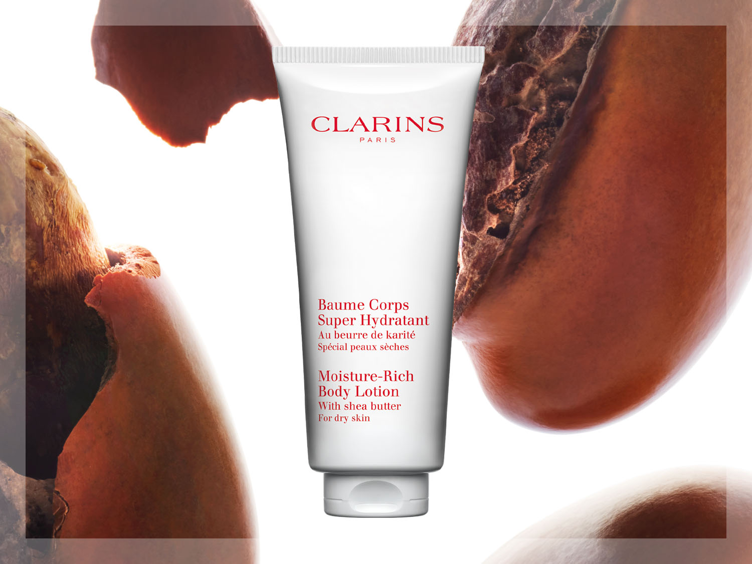 Loțiunea de corp Clarins Moisture-Rich, într-un tub alb, este îmbogățită cu unt de shea pentru a hidrata intens pielea uscată, având în fundal boabe de cacao.