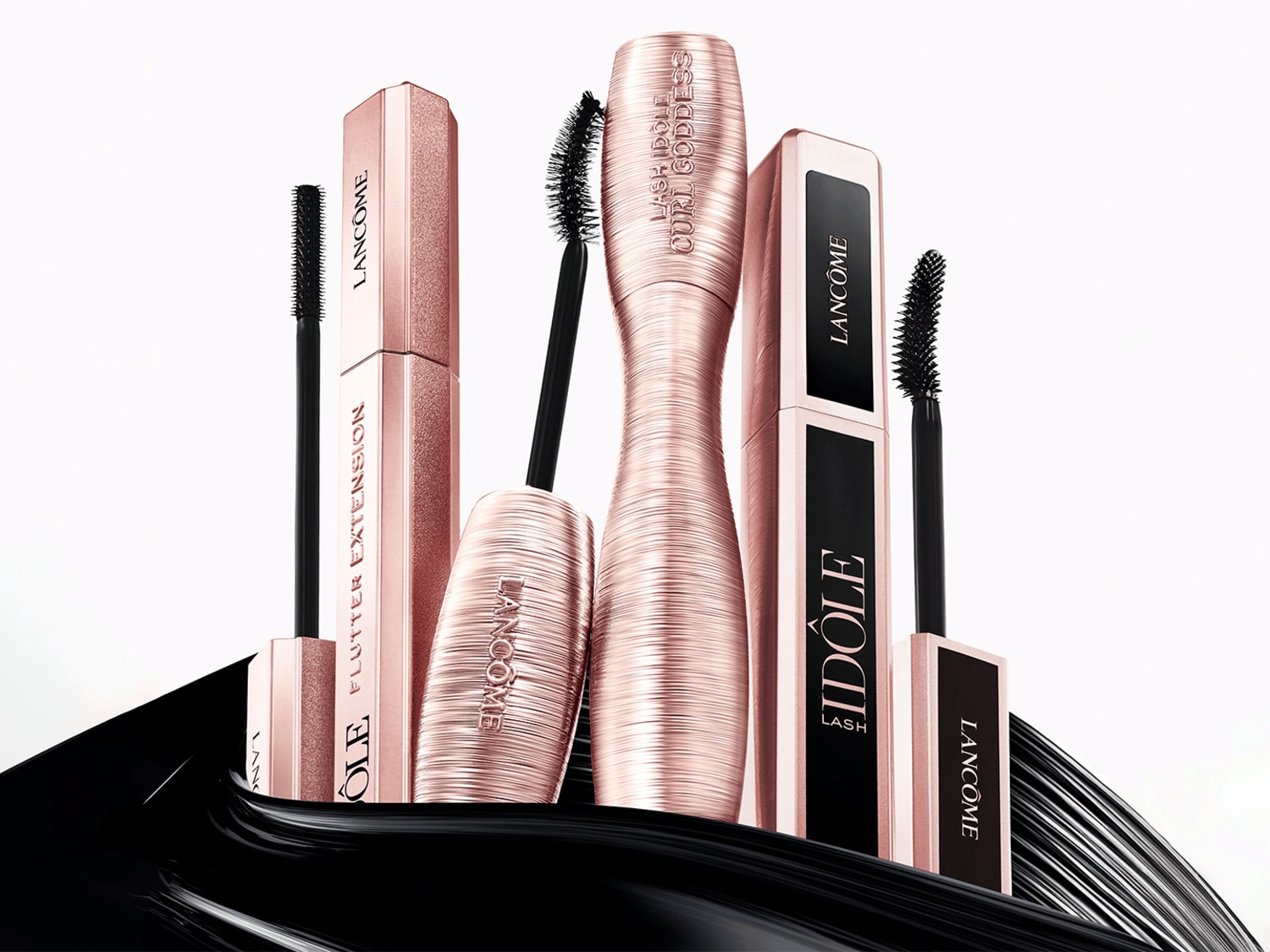 Řasenky Lancôme v růžovozlatém balení: IDÔLE pro objem a FLUTTER EXTENSION pro délku, obě s černými kartáčky pro dokonalé řasy.