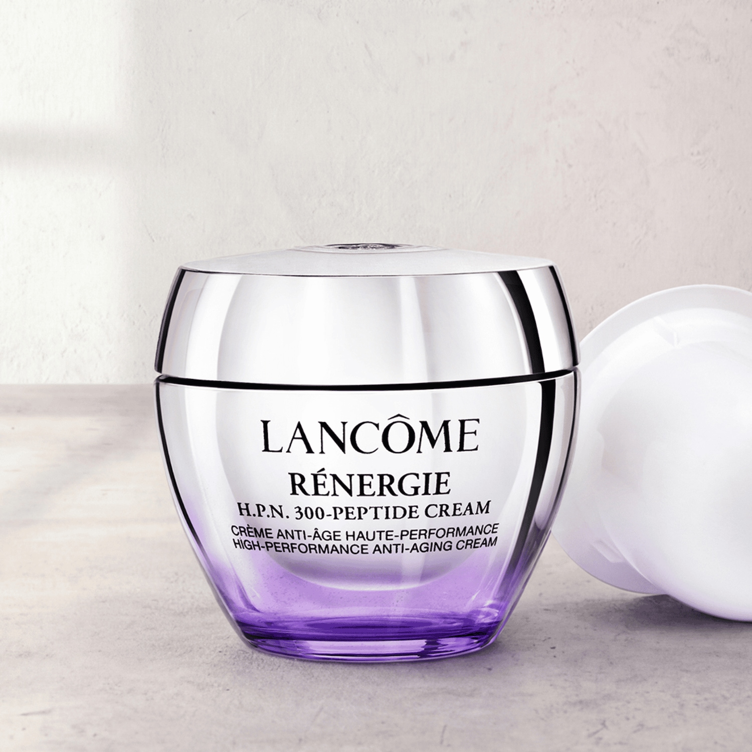 Krém Lancôme Rénergie H.P.N. 300-Peptide Cream v průhledné fialové nádobce se stříbrným víčkem slibuje vysoce účinnou péči proti stárnutí.
