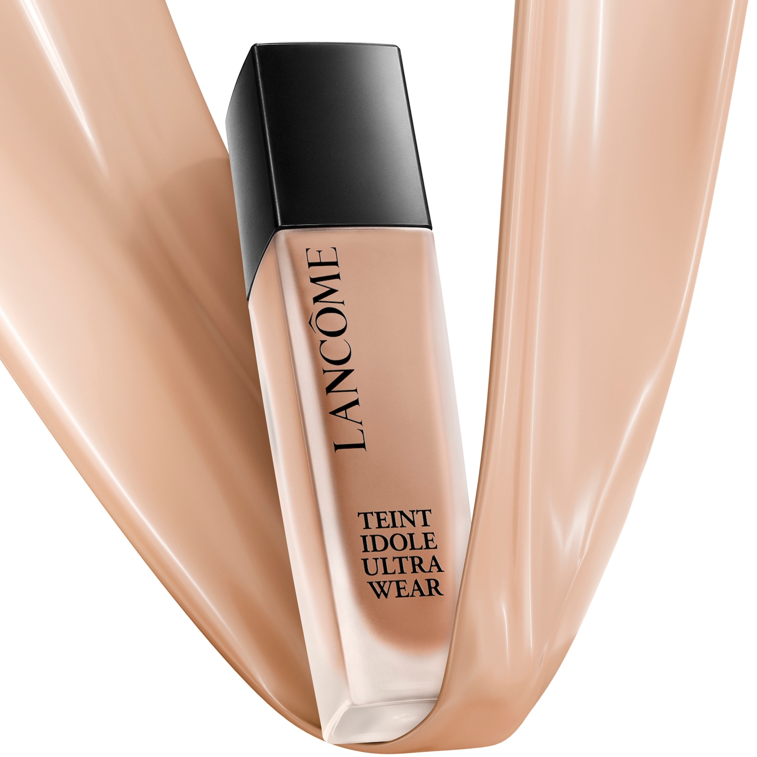 Lahvička make-upu Lancôme Teint Idole Ultra Wear s černým víčkem a béžovým make-upem obtéká béžová tekutina, což naznačuje jeho hladkou texturu.