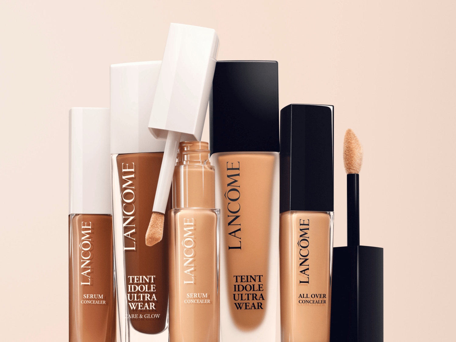 Řada korektorů Lancôme v odstínech od tmavě hnědé po světle béžovou, včetně Teint Idole Ultra Wear a Serum Concealer, s aplikátory.
