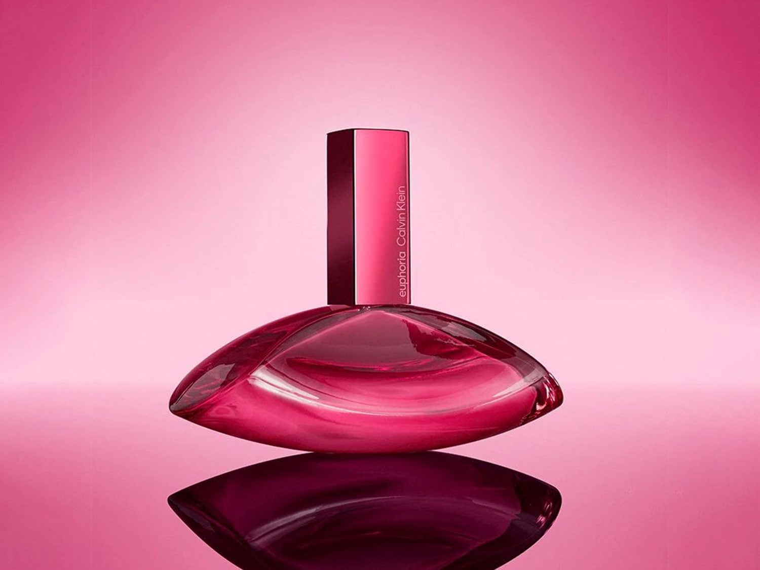 Sticla de parfum Calvin Klein Euphoria, într-o nuanță vibrantă de roz, cu un design elegant și modern, reflectând lumina pe suprafața lucioasă.