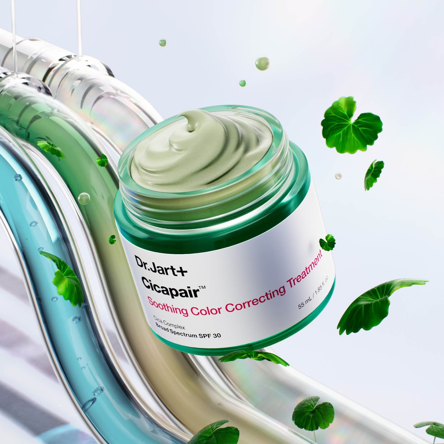 Krem Dr.Jart+ Cicapair™ Soothing Color Correcting Treatment w zielonym słoiczku z białą etykietą, otoczony zielonymi listkami i tubami w odcieniach zieleni i błękitu.