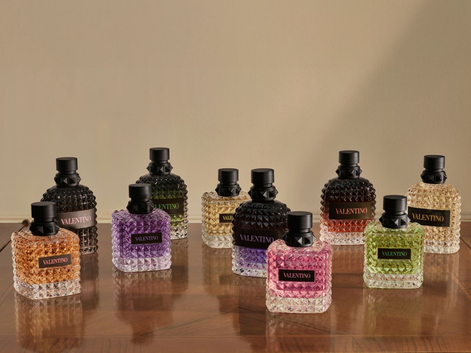 Découvrez la collection de parfums Valentino, présentée dans des flacons aux couleurs variées et aux textures uniques, chacun portant l'emblème de la marque.