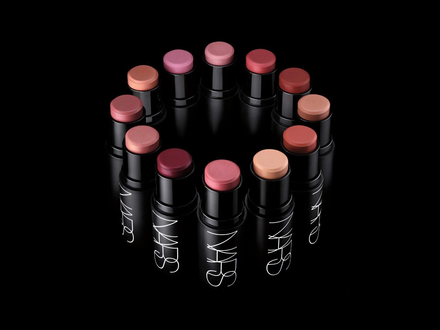 Découvrez un cercle de bâtons de blush NARS aux teintes variées, allant du rose pâle au bordeaux, présentés dans des tubes noirs élégants pour une touche de couleur subtile et sophistiquée.