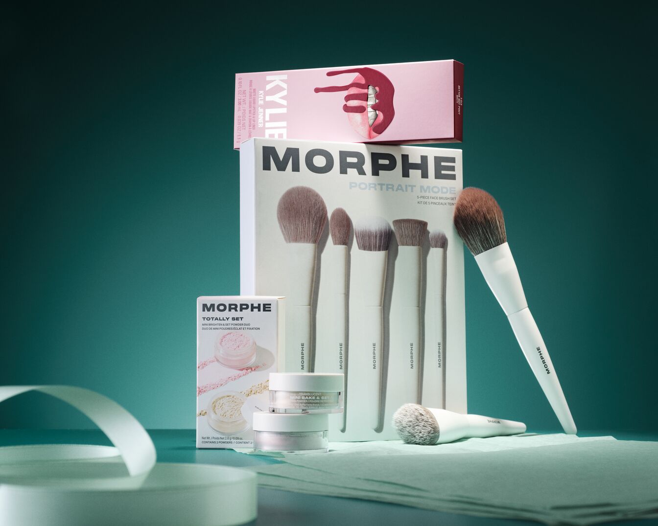 Šiame rinkinyje yra „Kylie Cosmetics“ lūpų dažai, „Morphe Portrait Mode“ 5 dalių veido šepetėlių rinkinys ir „Morphe Totally Set Mini Brighten & Set Powder Duo“.