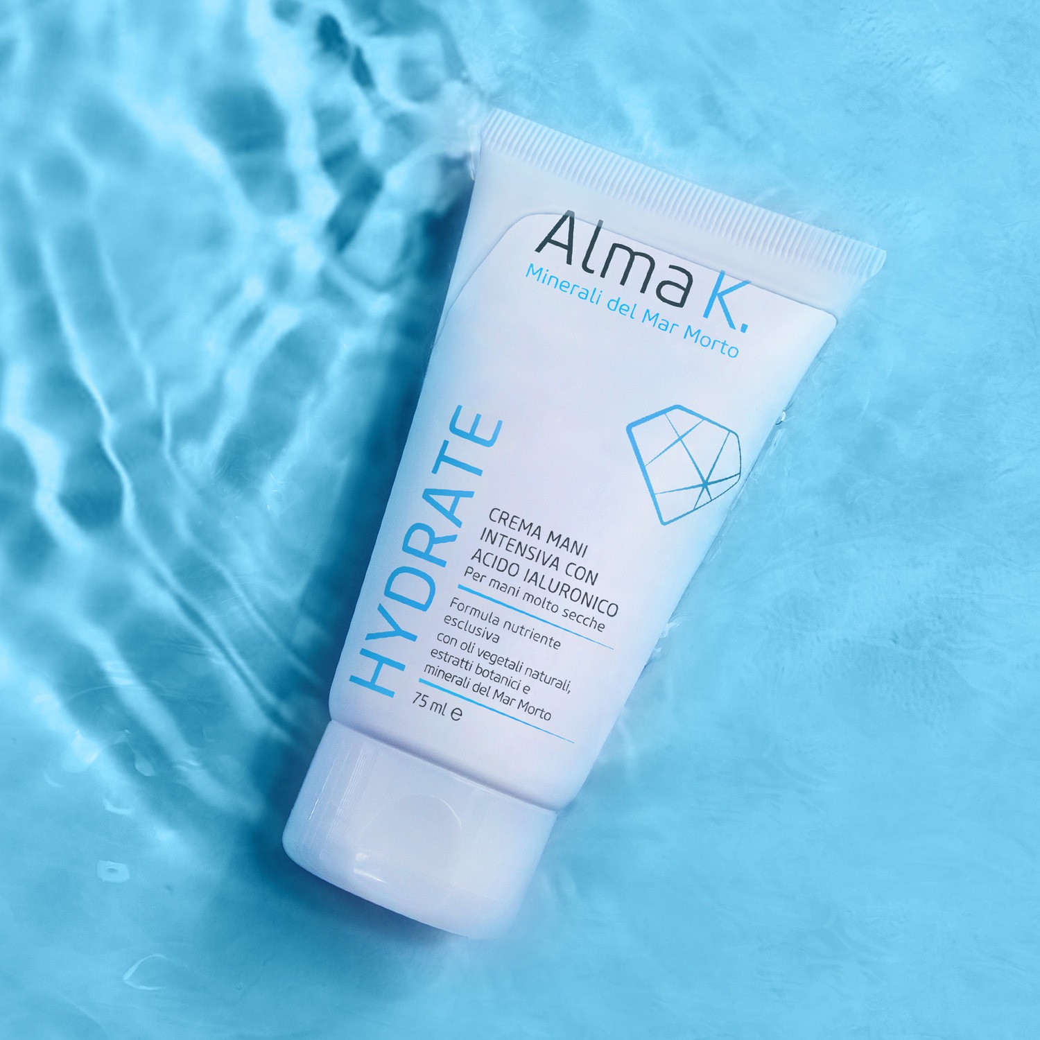 Crema mani Alma K. Minerali del Mar Morto, formula intensiva con acido ialuronico per mani molto secche, arricchita con oli vegetali naturali ed estratti botanici, in confezione bianca da 75ml.