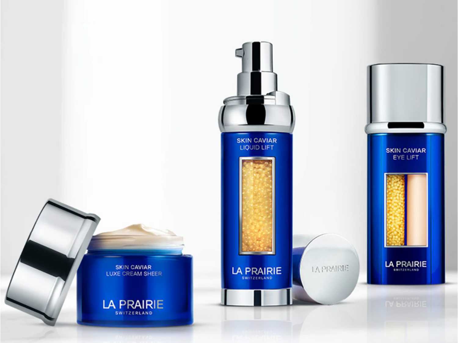 Kolekcja La Prairie Skin Caviar w niebieskich opakowaniach: luksusowy krem, liftingujący płyn i lifting pod oczy, zapewniające kompleksową pielęgnację skóry.