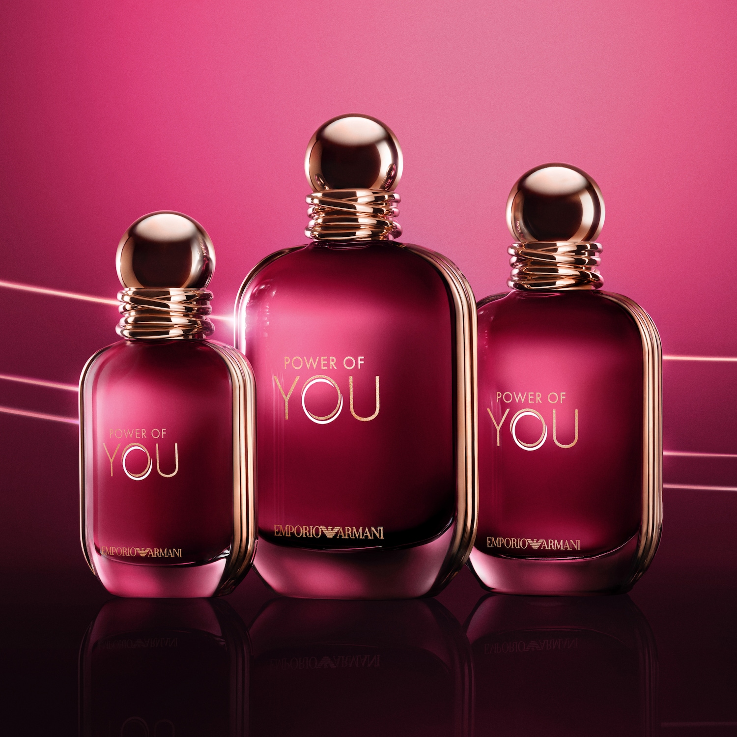 Három üveg Emporio Armani parfüm látható, bordó színűek, arany felirattal és kupakkal, a "Power of You" felirattal.