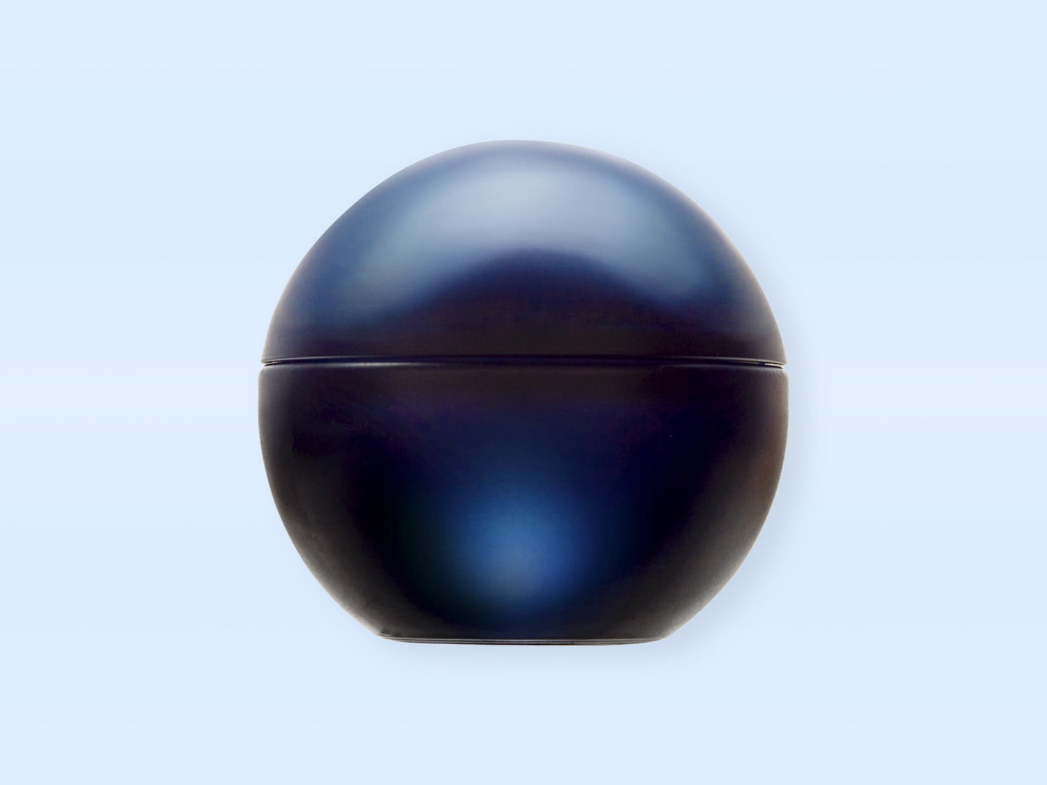 Ein glatter, dunkelblauer, eiförmiger Behälter mit einer dezenten horizontalen Linie in der Mitte, die den Deckel vom Boden trennt, steht auf einem hellblauen Hintergrund.