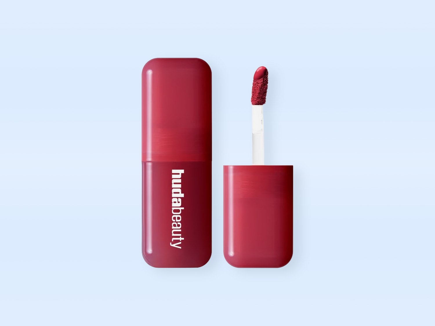 Ein Huda Beauty Lipgloss in einem satten Rotton, mit dem Applikator, der aus der Flasche ragt und die leuchtende Farbe des Produkts zeigt.