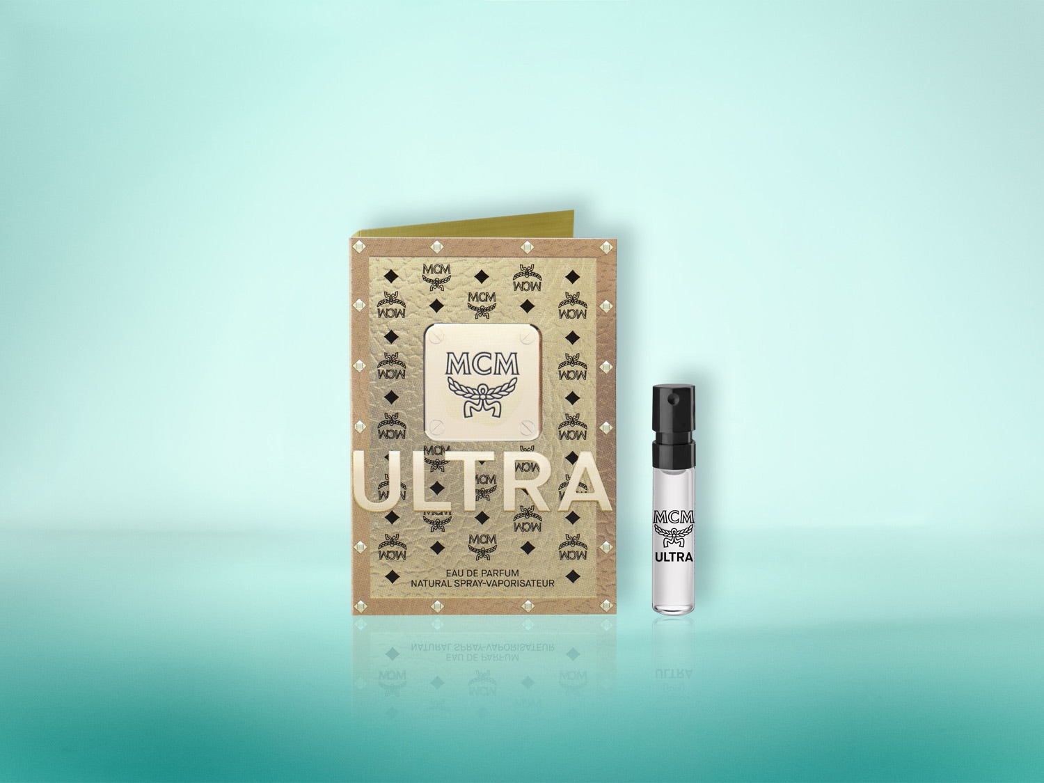 Das MCM Ultra Eau de Parfum ist ein natürliches Spray-Vaporisateur, das in einer goldfarbenen Verpackung mit dem MCM-Logo und dem Schriftzug "ULTRA" präsentiert wird, begleitet von einer kleinen, transparenten Probe mit schwarzem Sprühkopf.