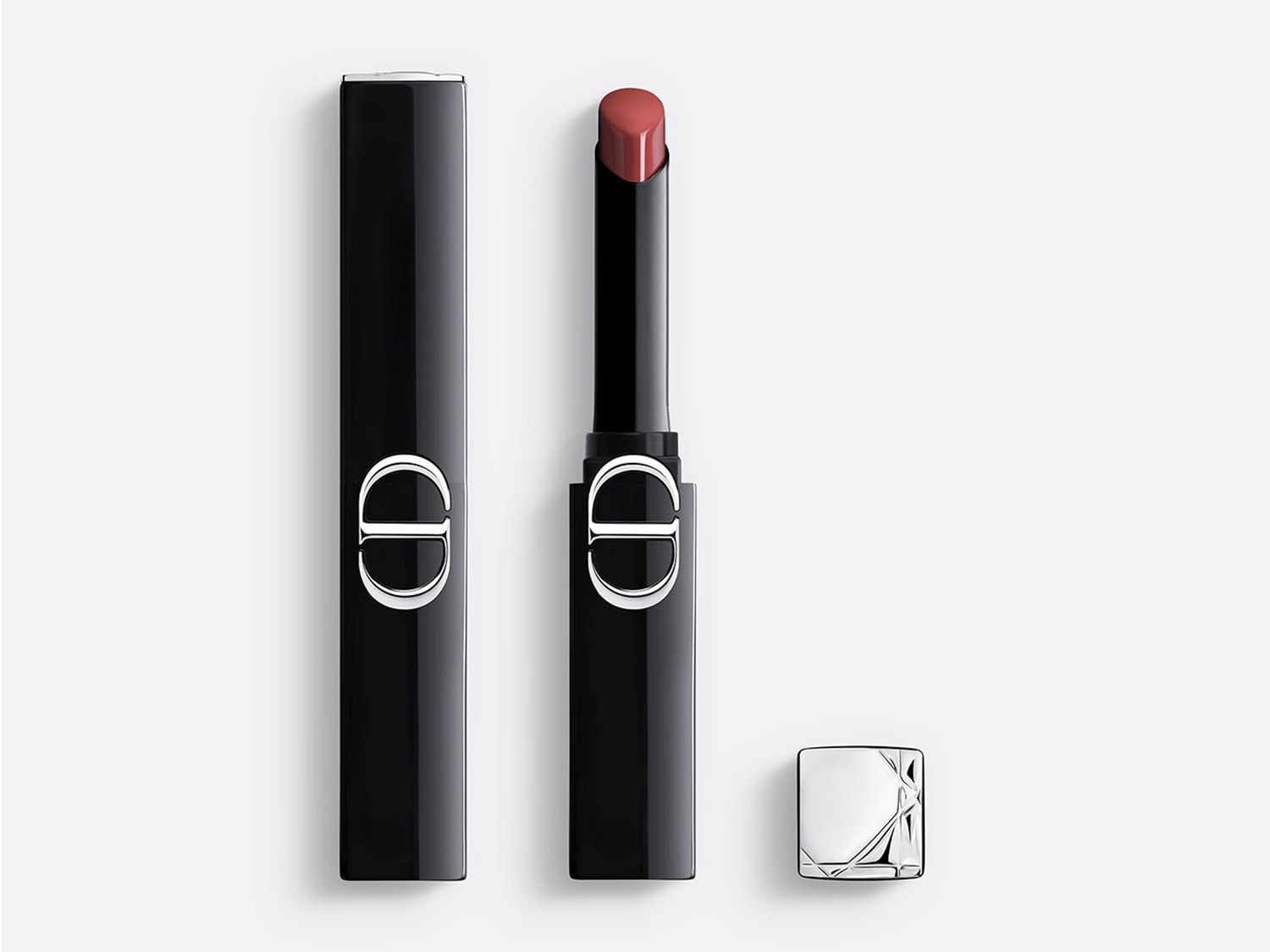 De Dior Addict Lipstick in een elegante zwarte huls met zilveren CD-logo, toont een zachtroze tint die klaar is voor gebruik, met de dop ernaast.