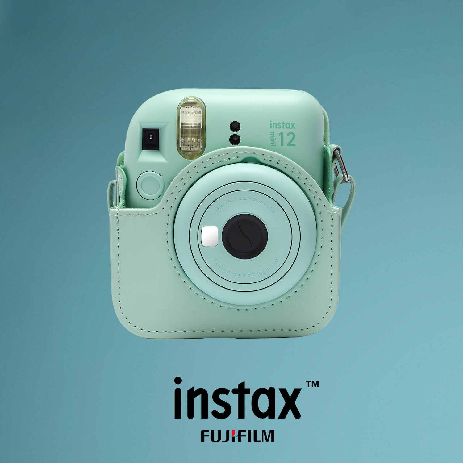 Die mintgrüne Instax Mini 12 Kamera mit passender Schutzhülle und dem Instax Fujifilm Logo auf blauem Hintergrund.