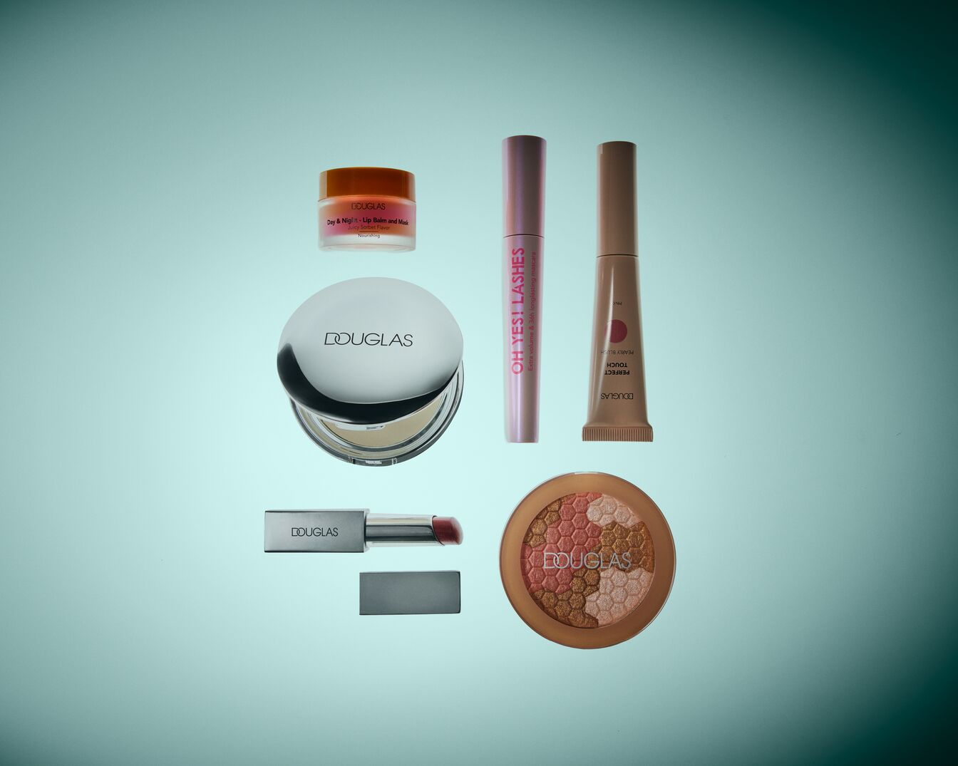 Sada kosmetiky Douglas zahrnuje balzám na rty, řasenku, make-up, rtěnku a tvářenku, vše úhledně uspořádané na světle modrém pozadí.