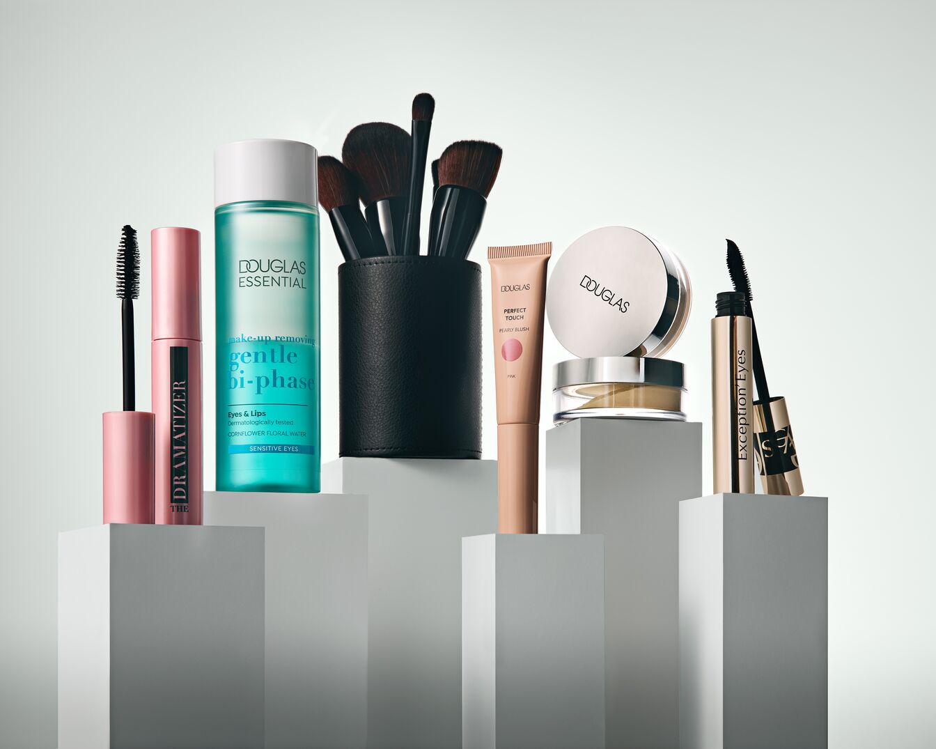 Sada kosmetiky Douglas Essential obsahuje řasenku Dramatizer v růžovém obalu, odličovač Gentle Bi-Phase pro oči a rty, sadu štětců na make-up v černém pouzdře, tvářenku Perfect Touch Pearly Blush, pudr a řasenku Exception'Eyes.