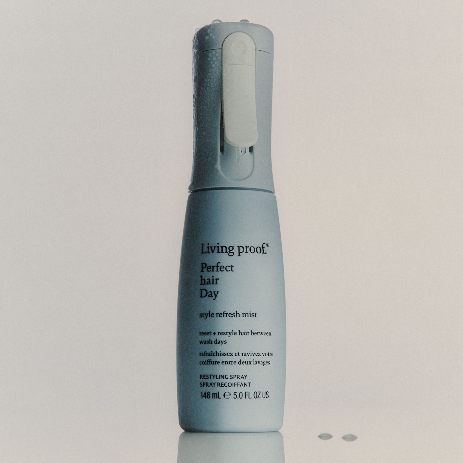 Das Living Proof Perfect Hair Day Style Refresh Mist ist ein hellblaues Spray in einer Flasche mit weißem Sprühkopf, das Ihr Haar zwischen den Haarwäschen erfrischt und neu stylt.