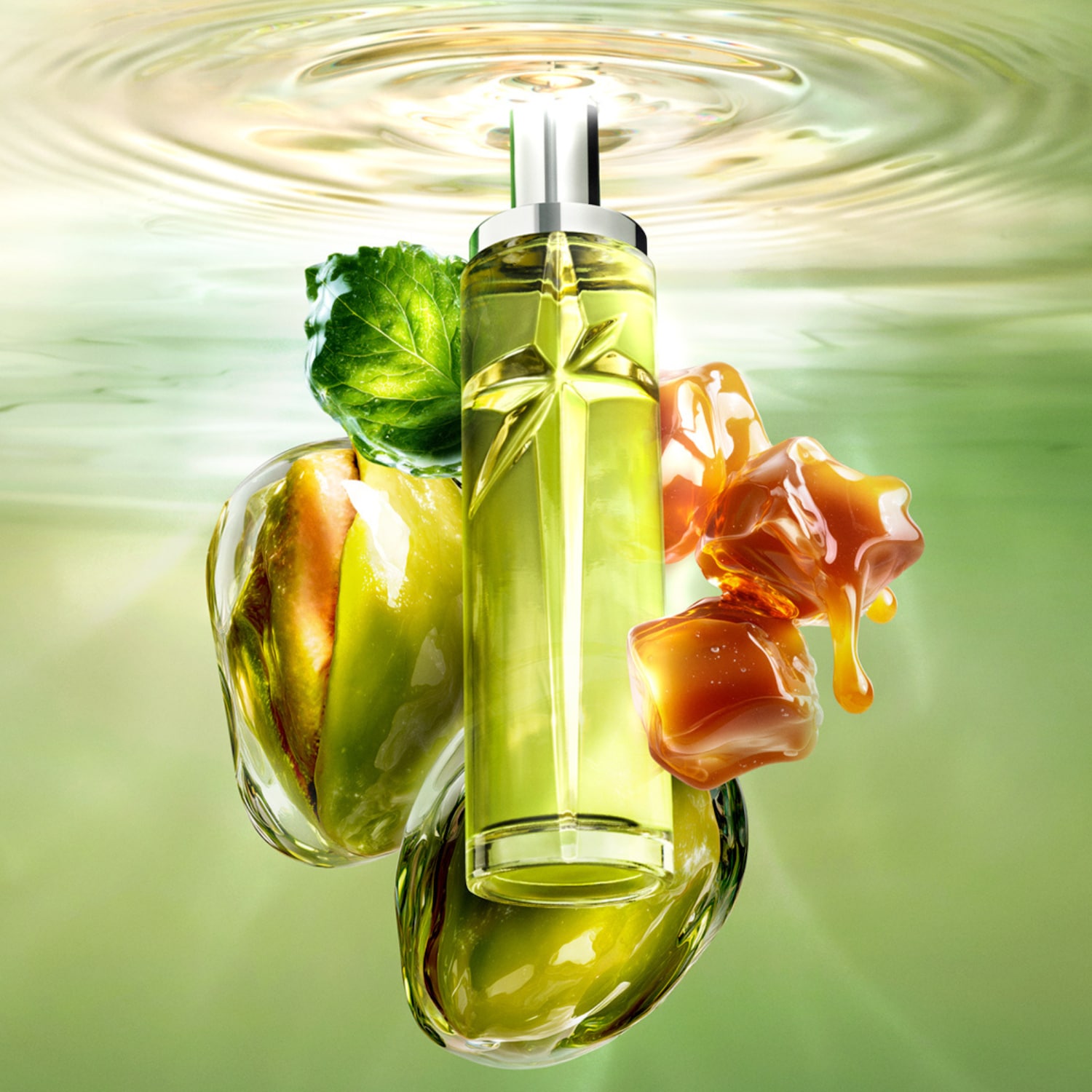 Le parfum Angel Eau de Parfum de Mugler est présenté dans un flacon en verre transparent en forme d'étoile, rempli d'un liquide vert clair, entouré de feuilles vertes, de pommes vertes et de caramel coulant, le tout sur un fond vert clair avec des ondulations d'eau en haut.