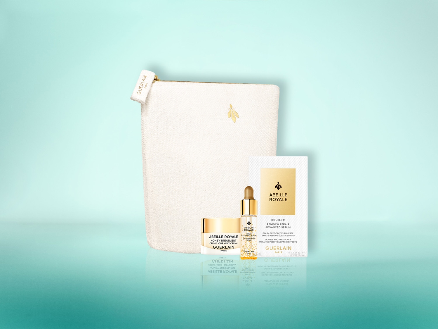 Das Guerlain Abeille Royale Set enthält eine weiße Kosmetiktasche mit goldenem Bienenlogo, eine goldene Flasche Advanced Serum, eine goldene Dose Tagescreme und eine weiße Produktkarte mit goldenem Bienenlogo.
