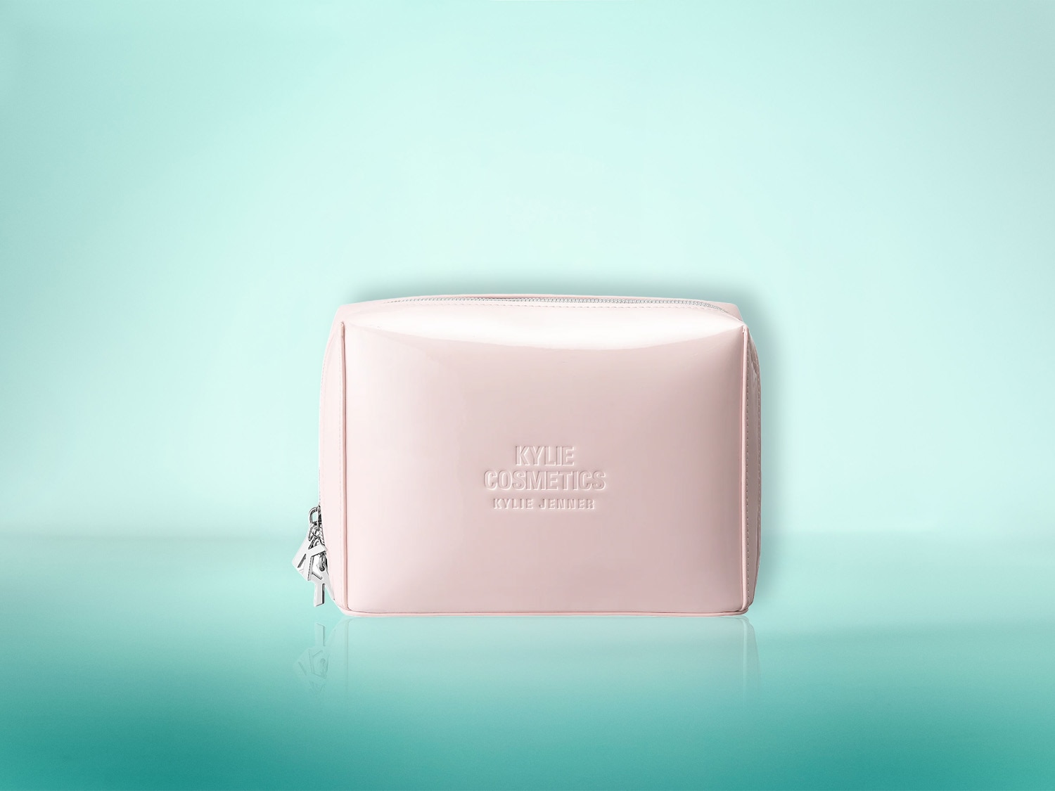 Die hellrosa Kosmetiktasche von Kylie Cosmetics mit dem Schriftzug „Kylie Cosmetics by Kylie Jenner“ auf der Vorderseite ist ein stilvolles Accessoire für Ihre Beauty-Produkte.